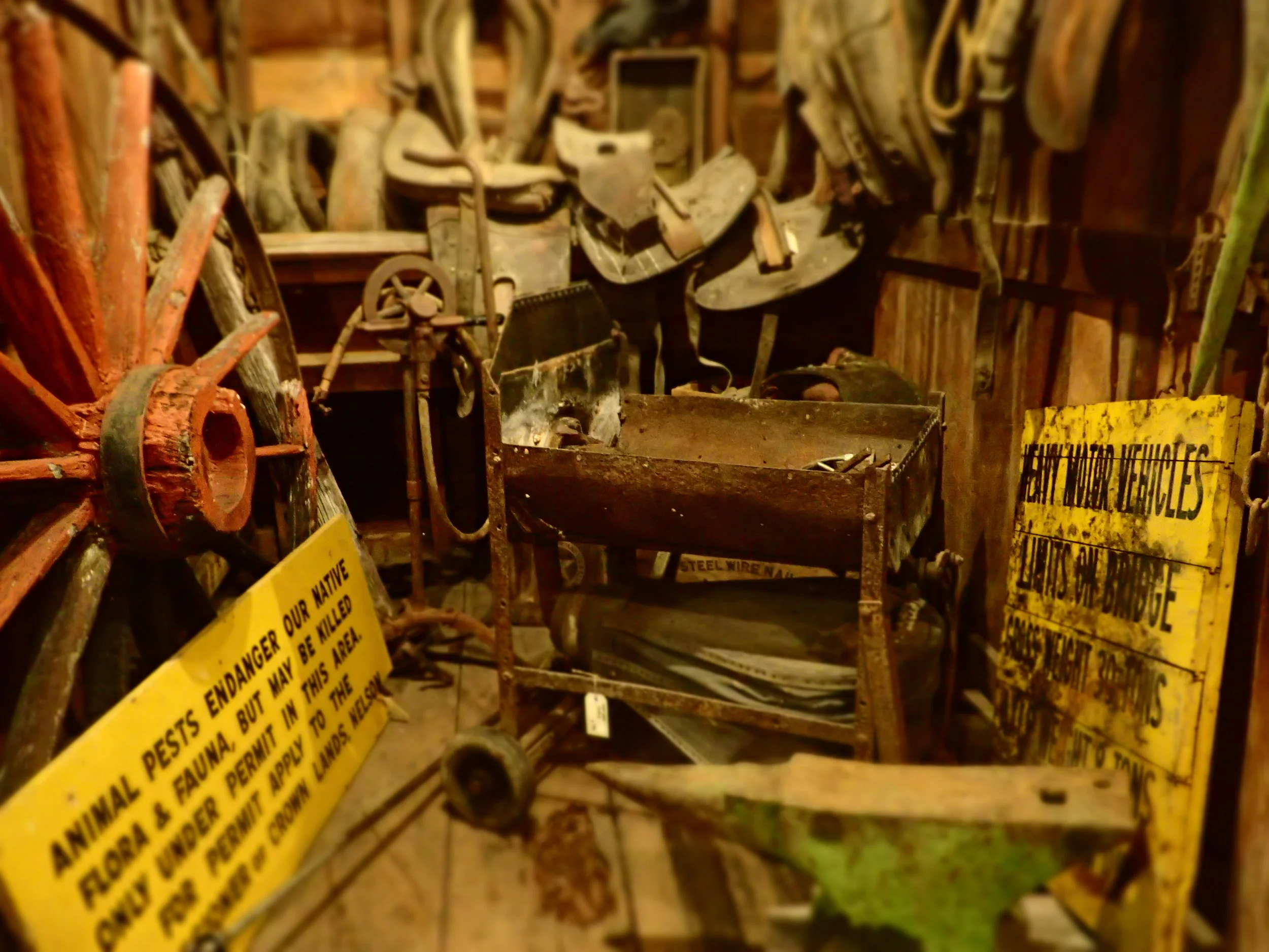 Raw and unrestored blacksmith's tools & horse cart gear in the horse box, hand operated forge and anvil.