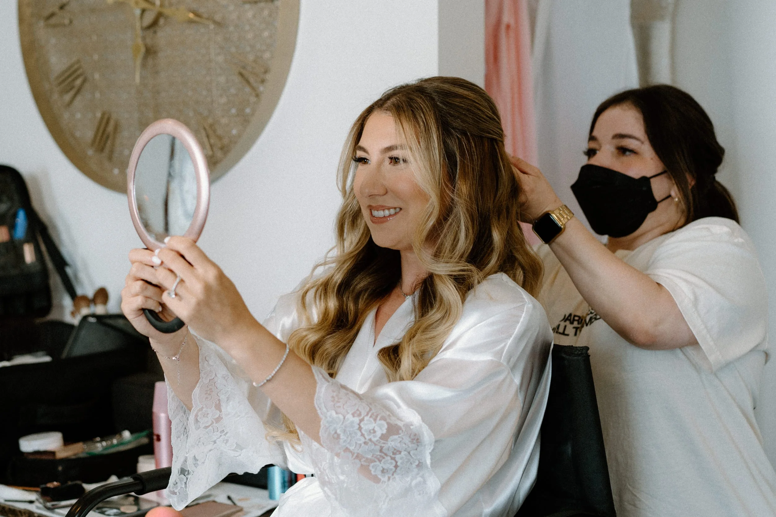 Bride smiling while getting her hair done on wedding day at The Manor House