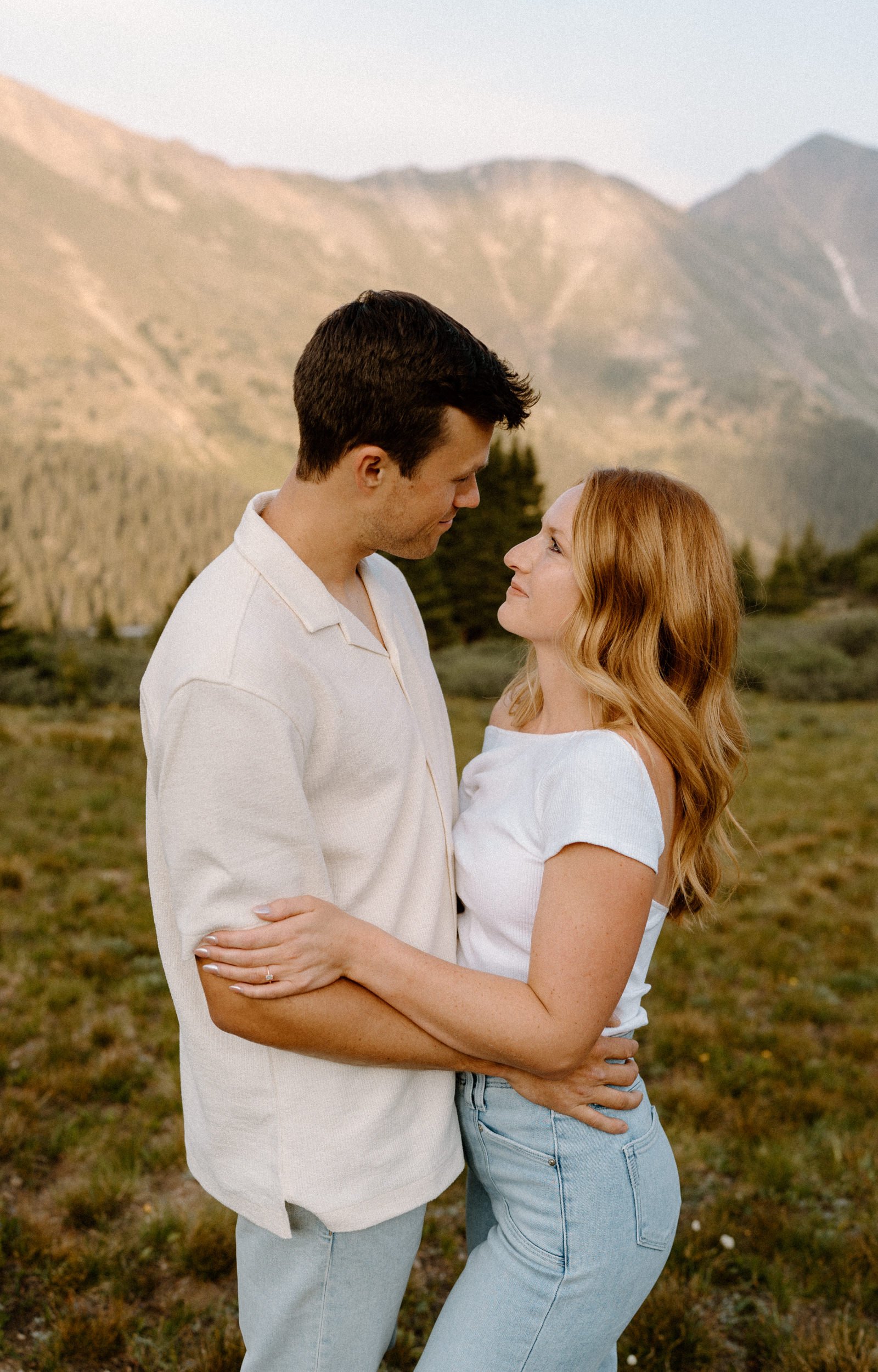 Couple hugging and looking at each other during engagement session at Loveland Pass