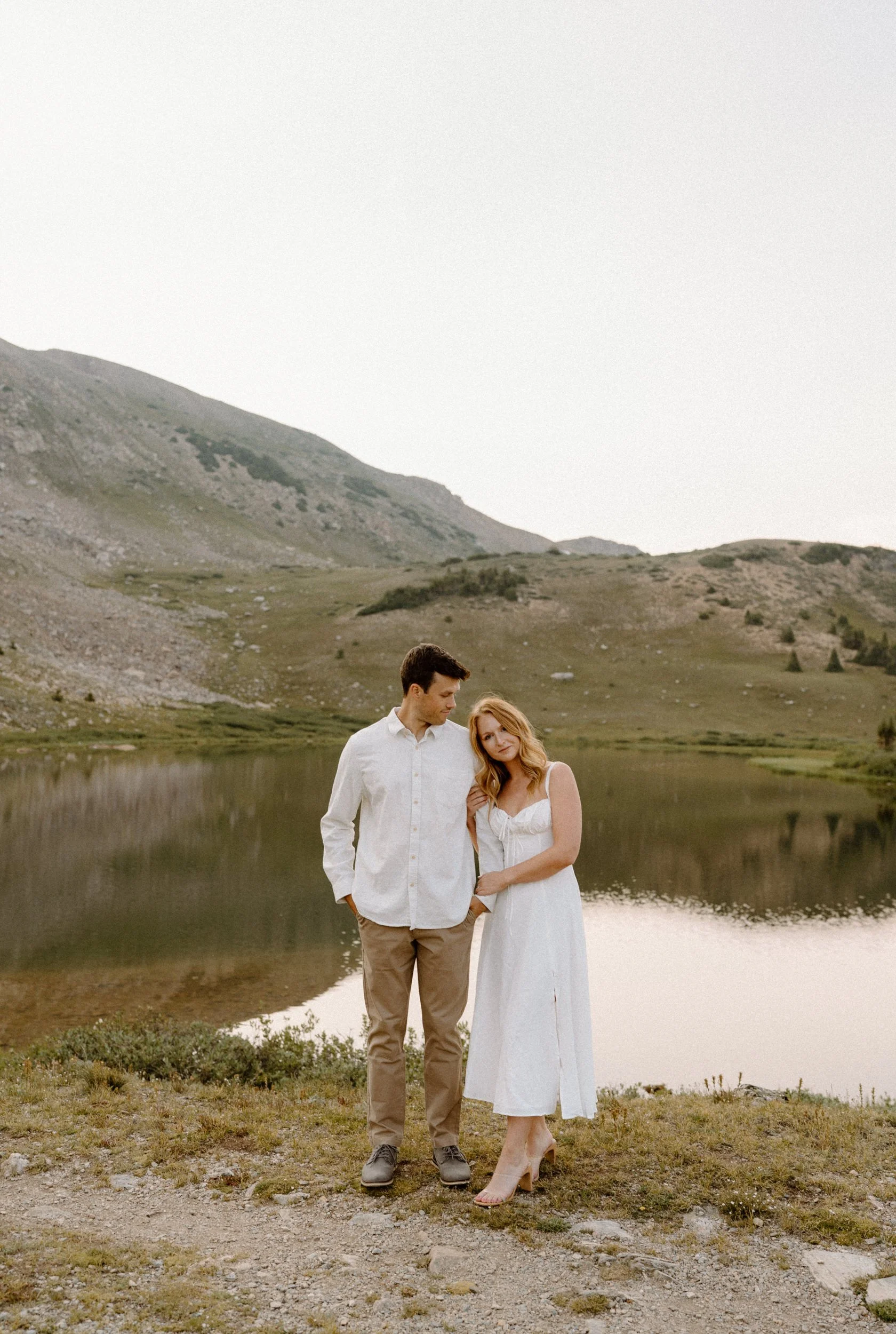 Fiancée looking at the camera and hugging fiancé during an engagement session at Loveland Pass