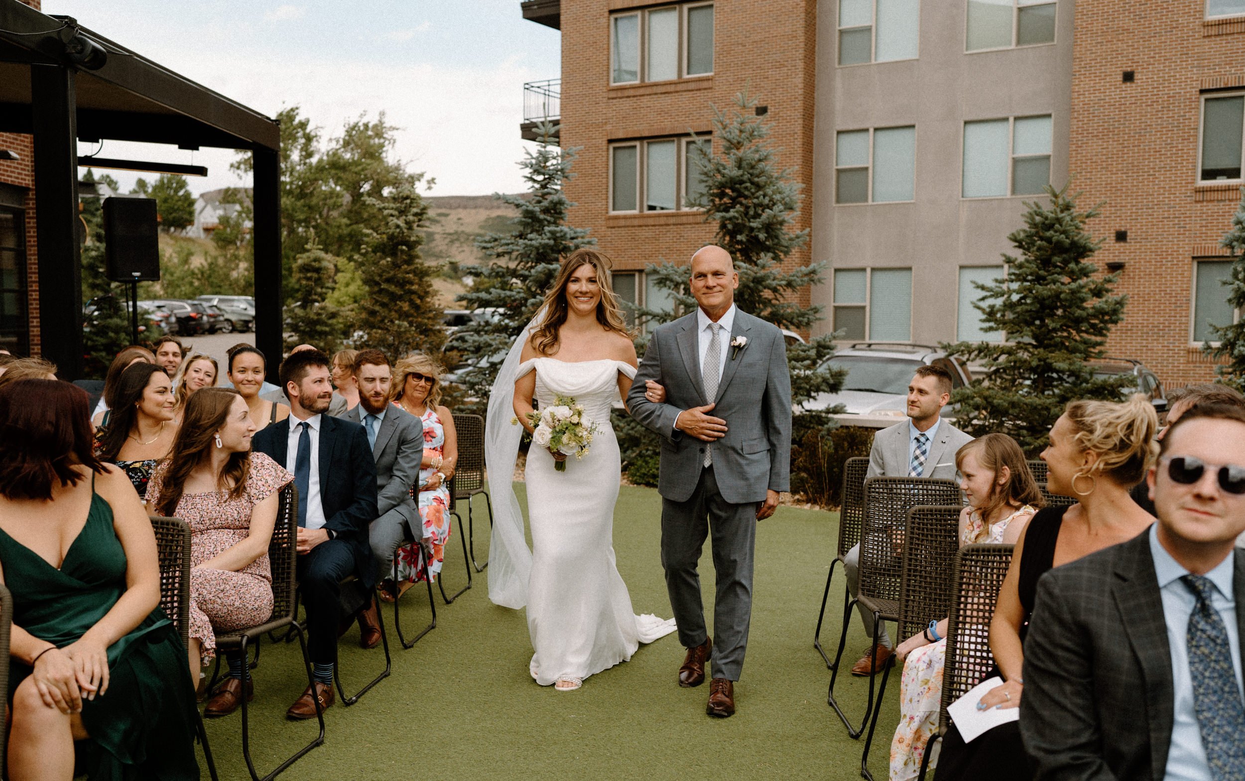 Bride and her dad walking down the aisle on The Eddy in Golden Colorado on wedding day