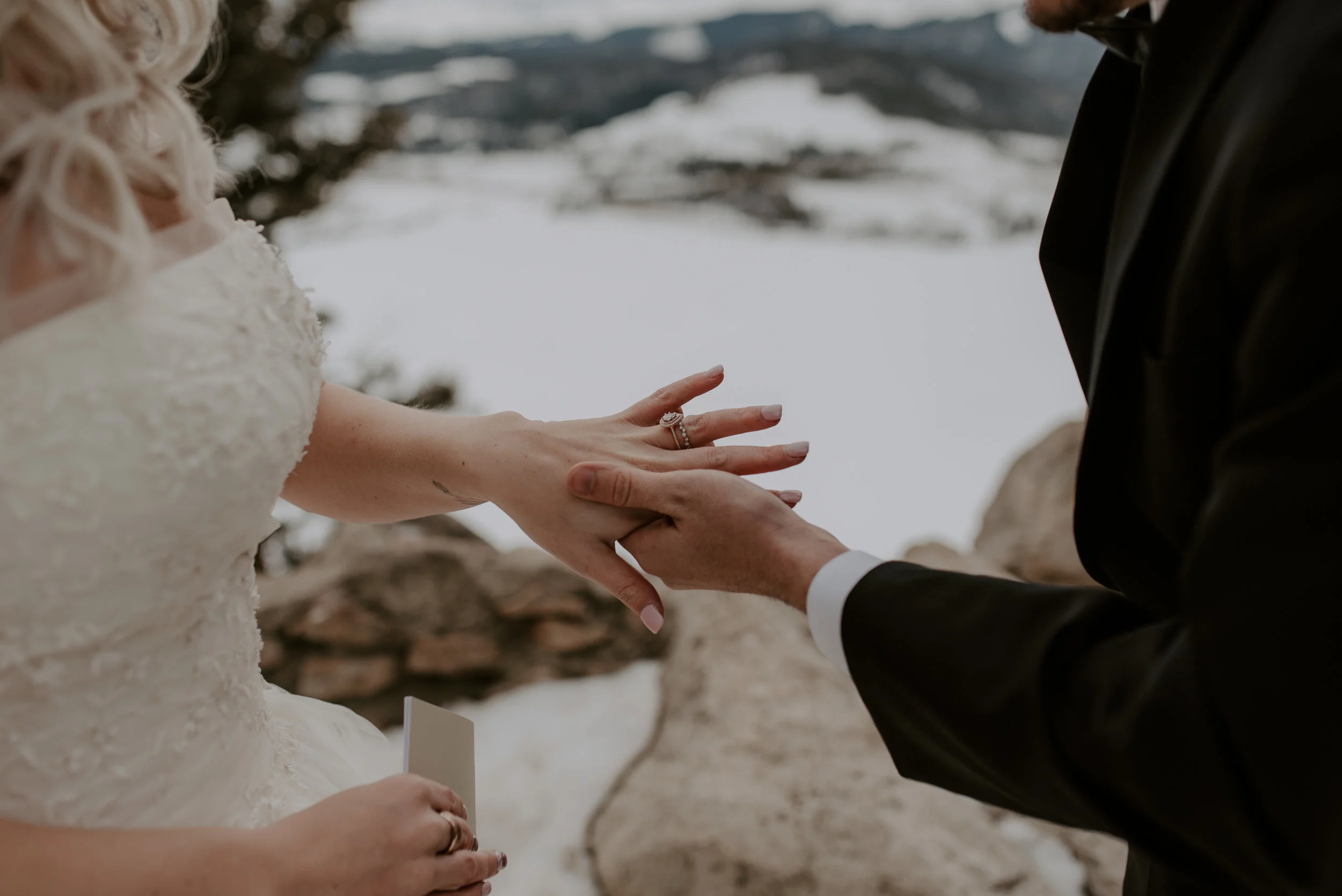  Groom putting on the bride's ring at a winter elopement at Sapphire Point in Dillon, Colorado. Denver, Colorado based elopement and wedding photographer. 