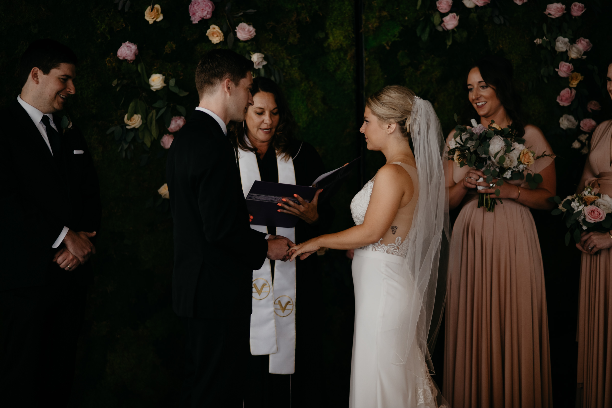  Groom putting on bride's ring at downtown Denver Moss wedding. Colorado wedding photography. 