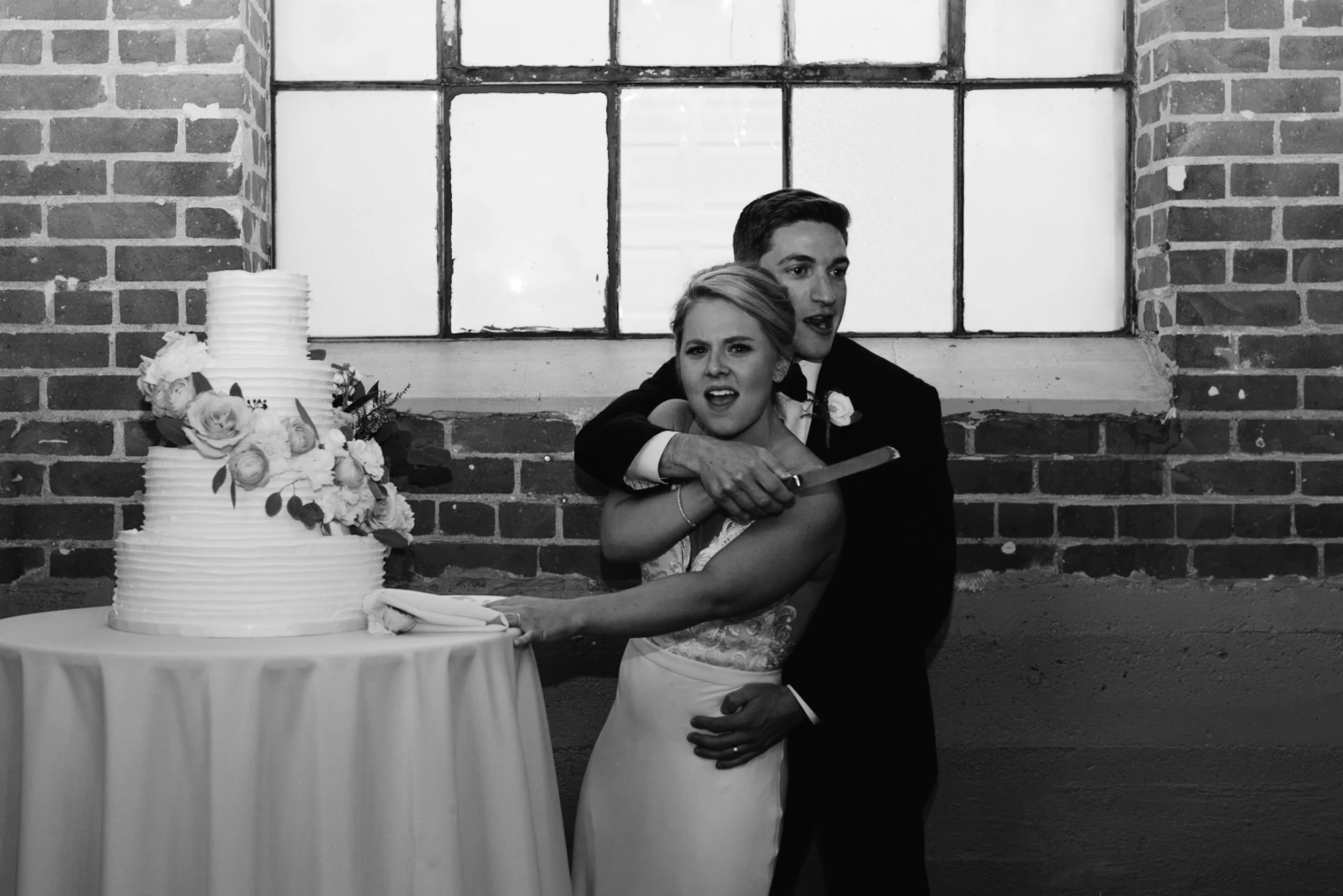  Downtown Denver wedding at Moss. Bride and groom cutting cake. 