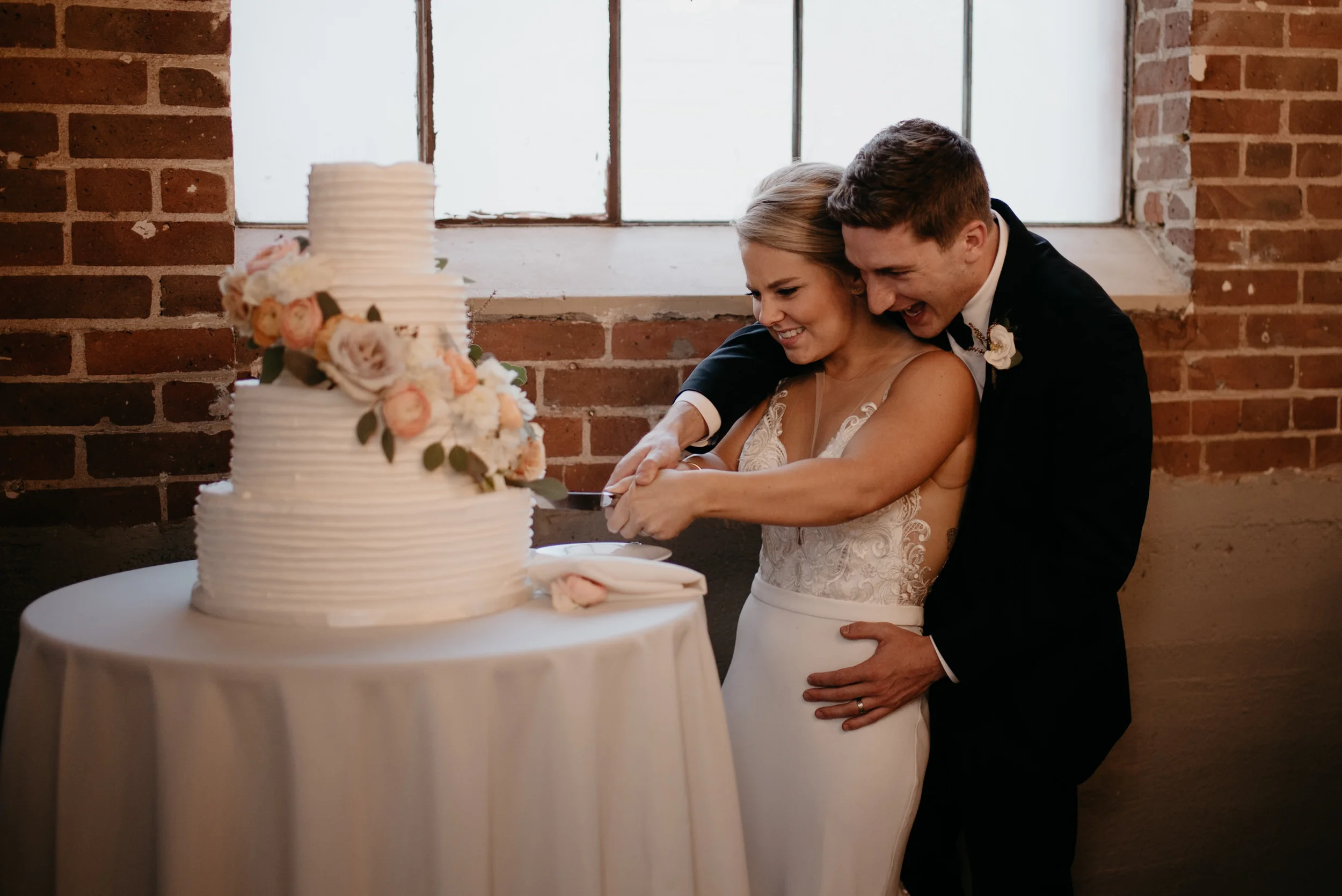  Bride and groom cut cake. Wedding at Moss in Denver. Downtown Denver wedding photographer. 