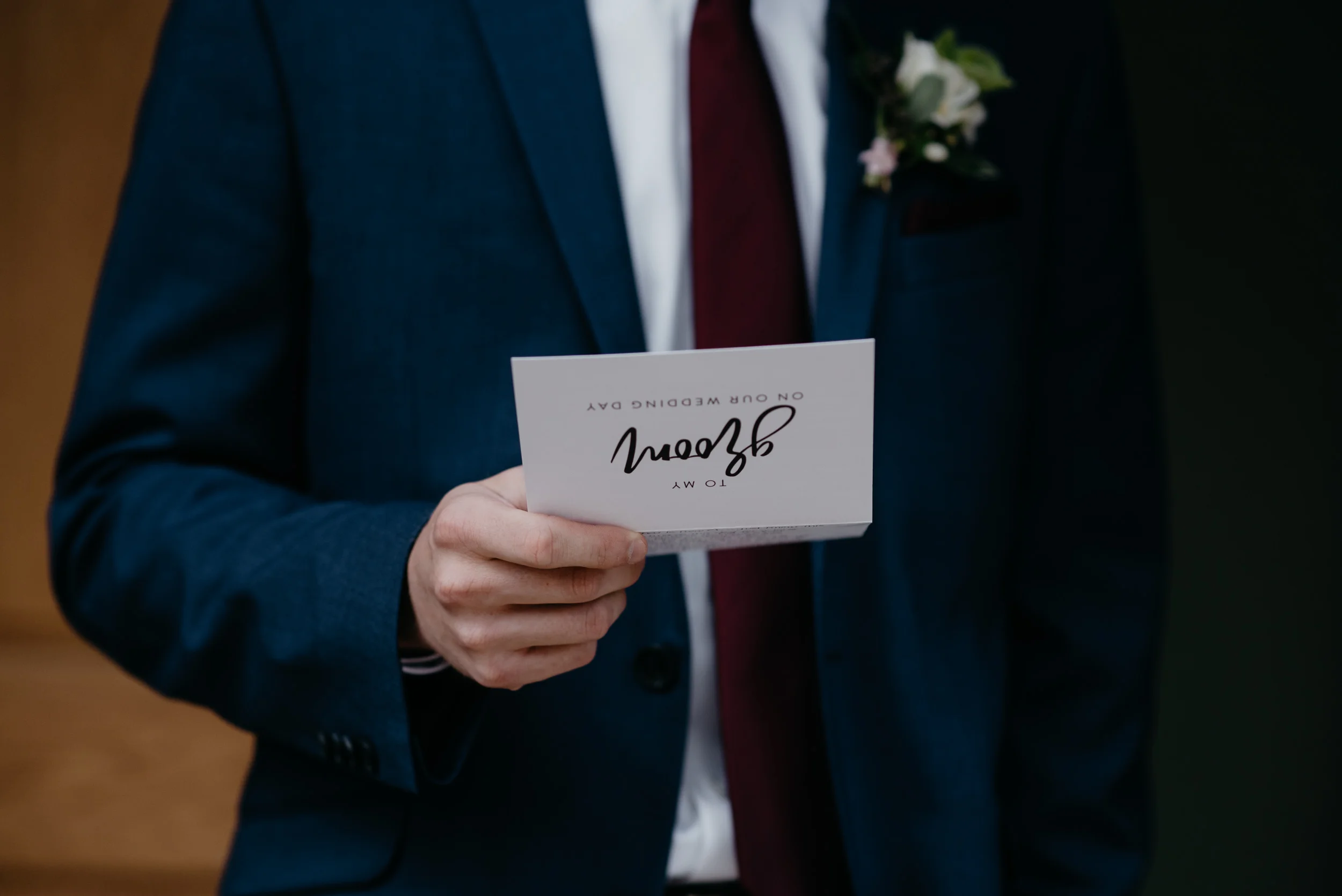  Colorado wedding photographer. Groom opening gift at Rocky Mountain National Park elopement. 