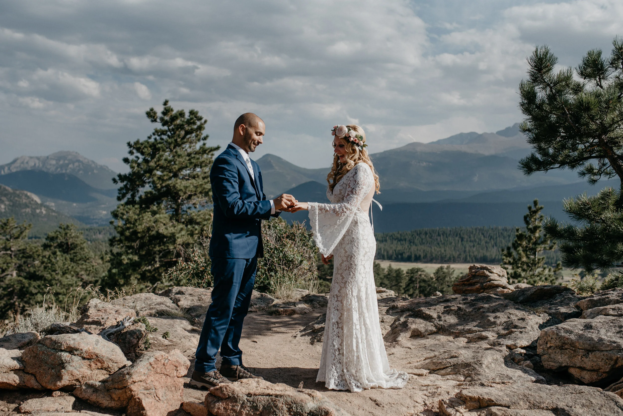  Groom putting on ring at intimate ceremony in Rocky Mountain National Park at 3M curve. 