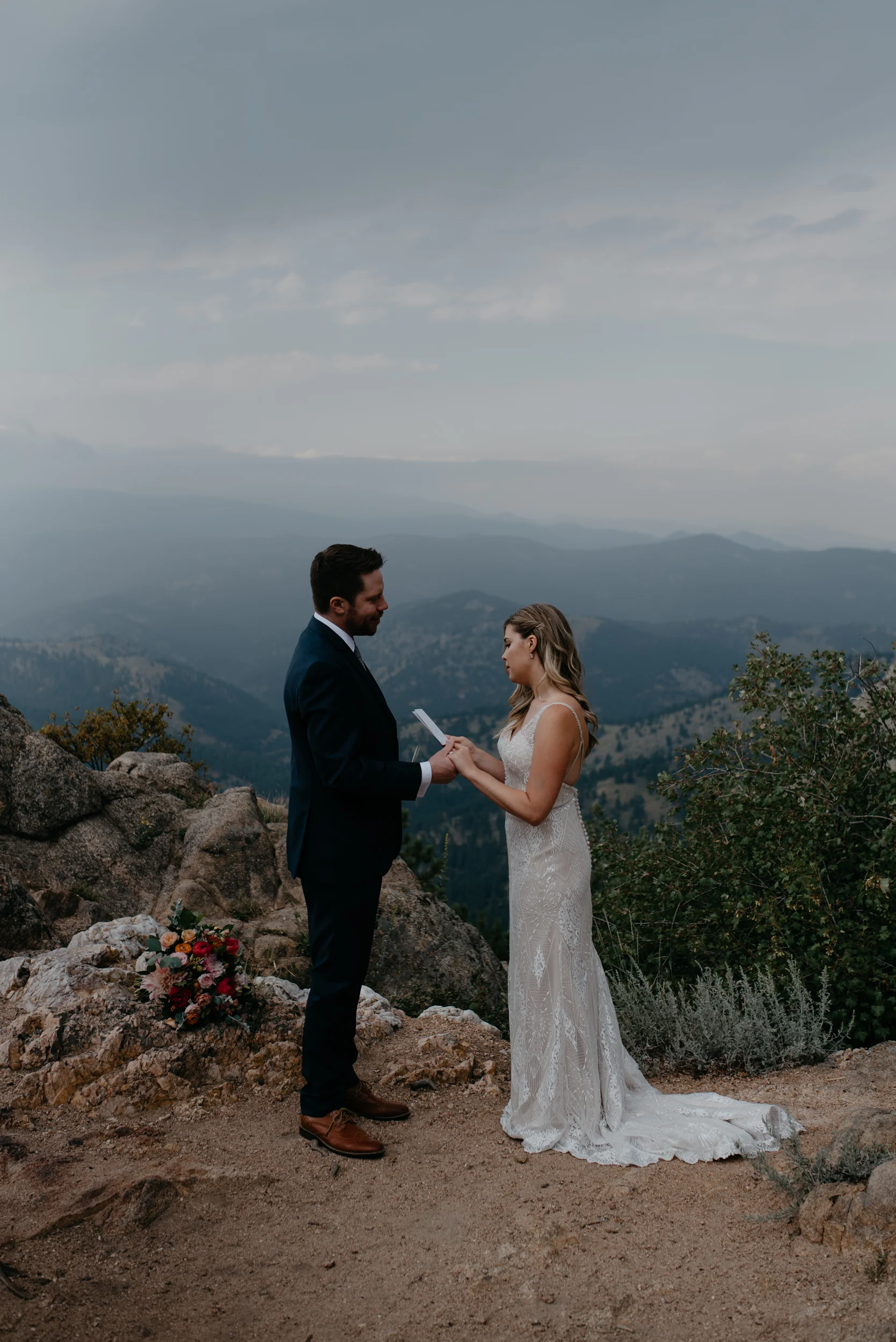  Bride and groom exchanging vows at a mountaintop elopement in Boulder, Colorado. Denver wedding and elopement photographer for adventurous couples. 