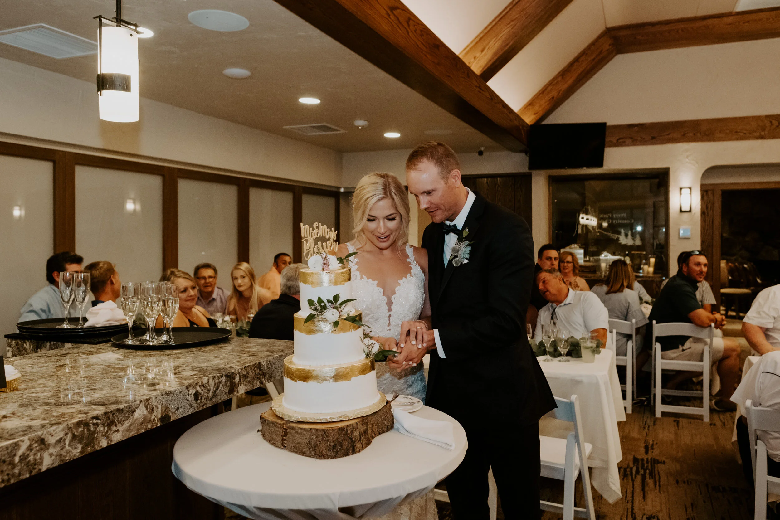  Cake cutting at Perry Park Country Club in Larkspur, Colorado. Larkspur, Colorado wedding venue. Perry Park Country Club wedding. Colorado wedding and elopement photographer. Colorado wedding photography. Perry Park Country club wedding photos. Couple cutting cake ideas. Perry Park wedding. 