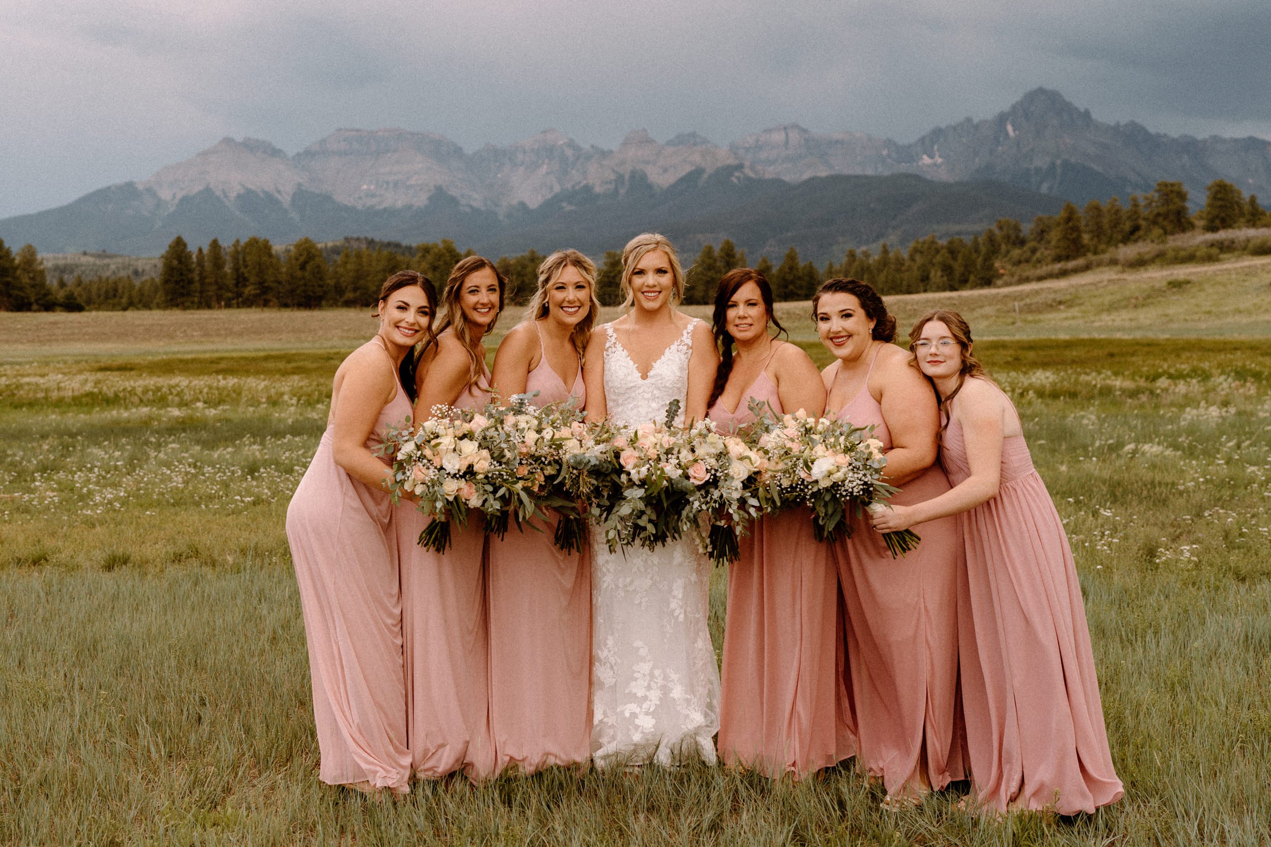Bride poses outside with her bridesmaids at Top of the Pines in Ridgway, CO