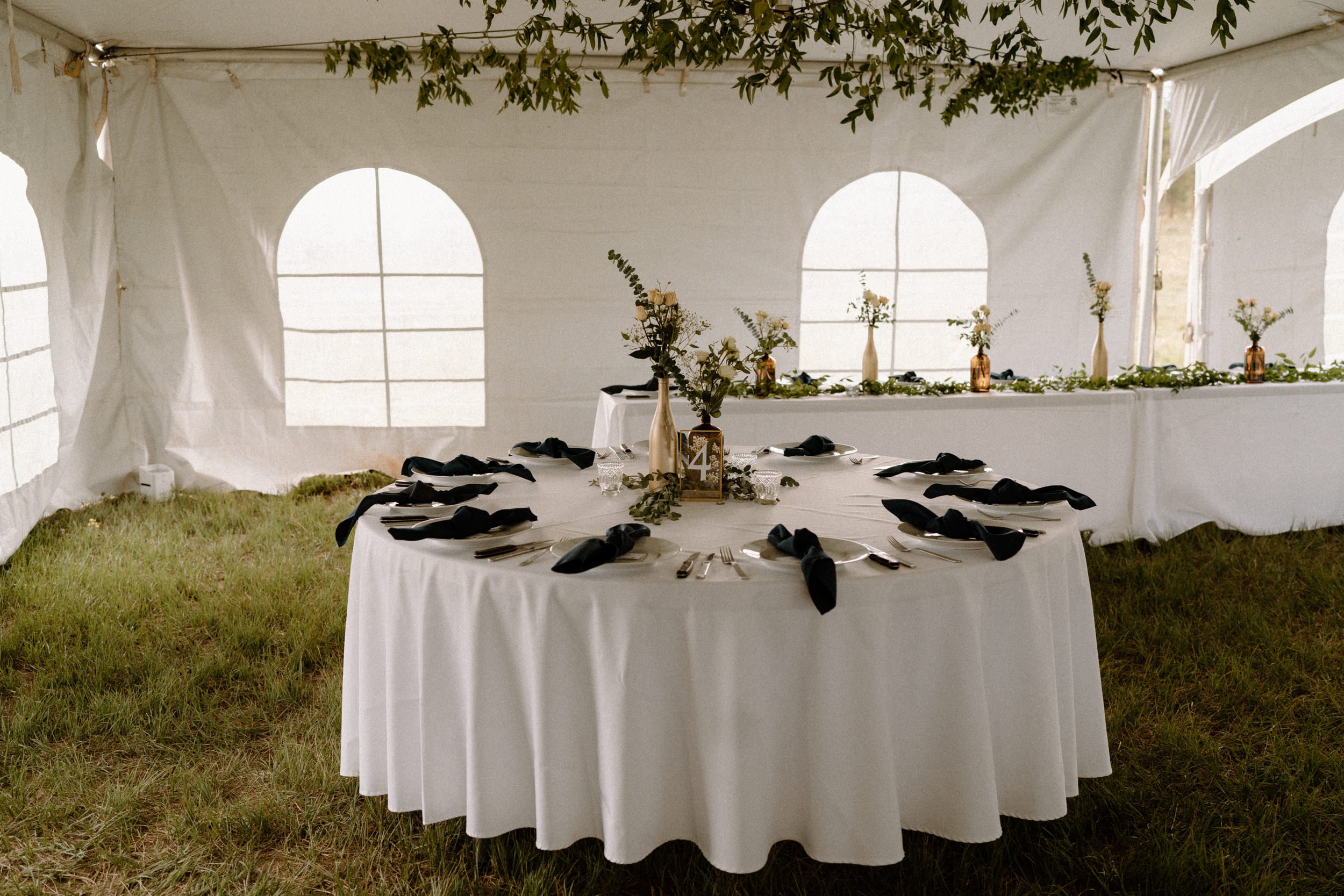White reception tables decorated with flowers