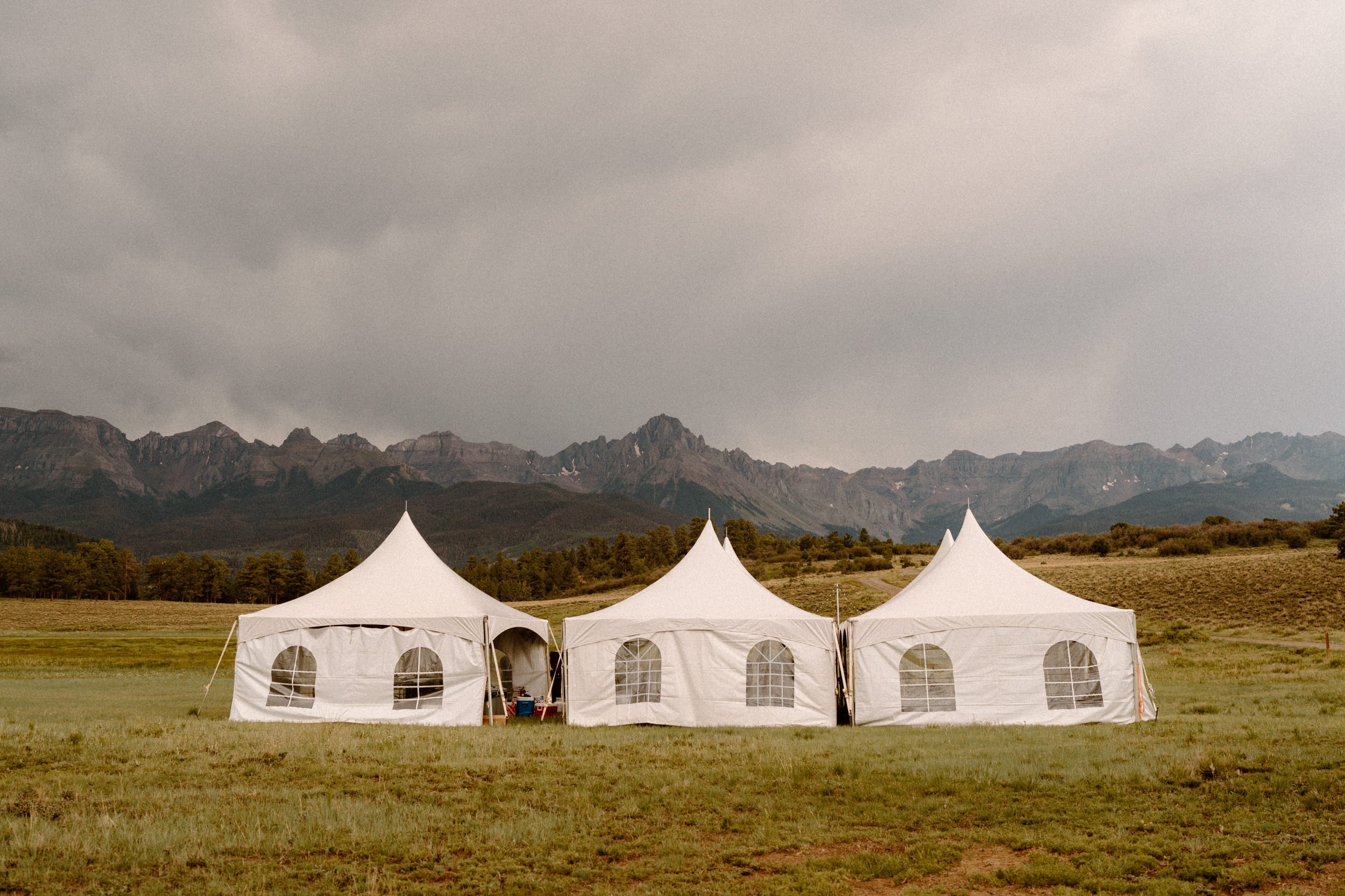 White tents sit below the base of mountains at Top of the Pines in Ridgway, CO