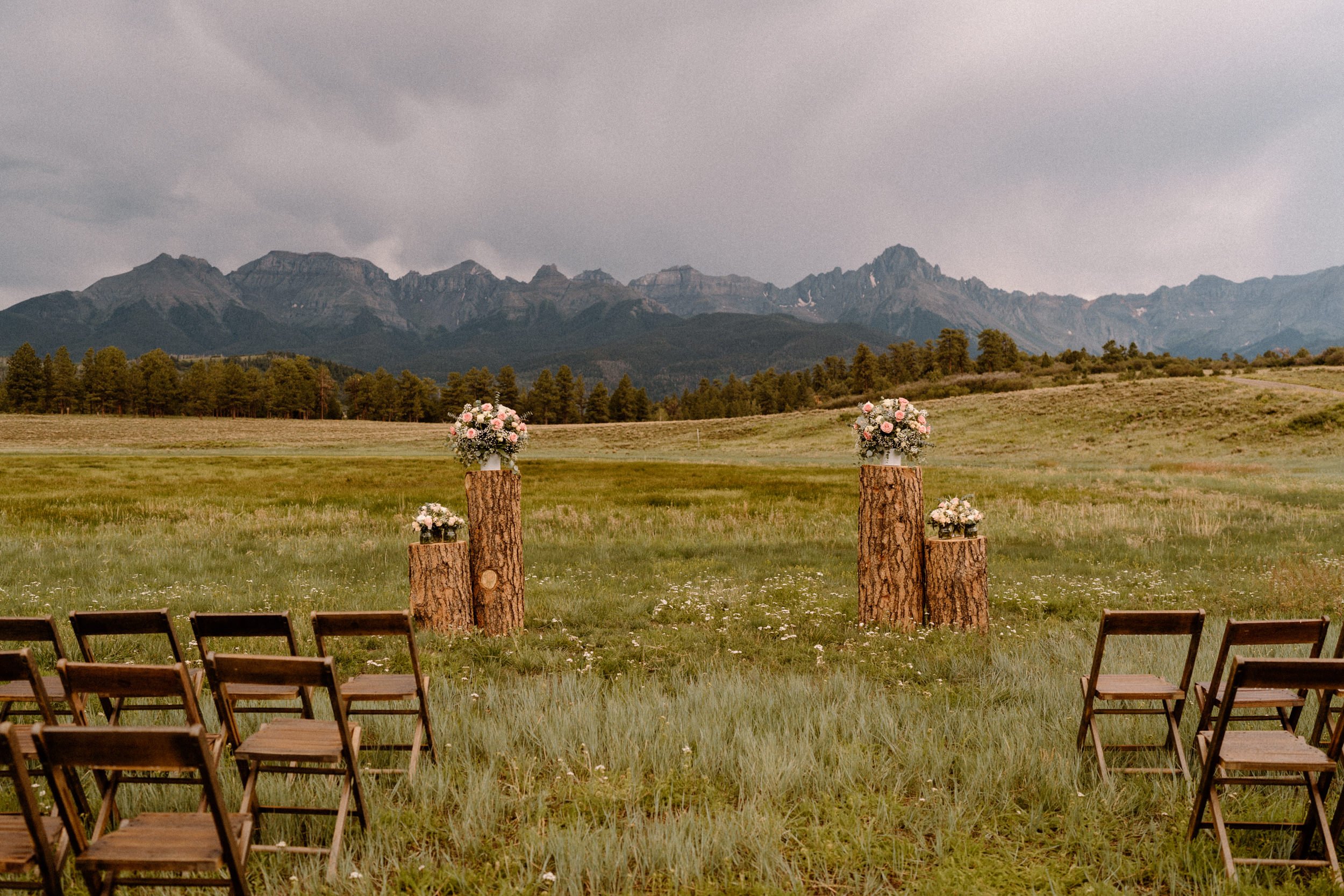 Tree stumps with flower bouquets mark the altar at Top of the Pines in Ridgway, CO