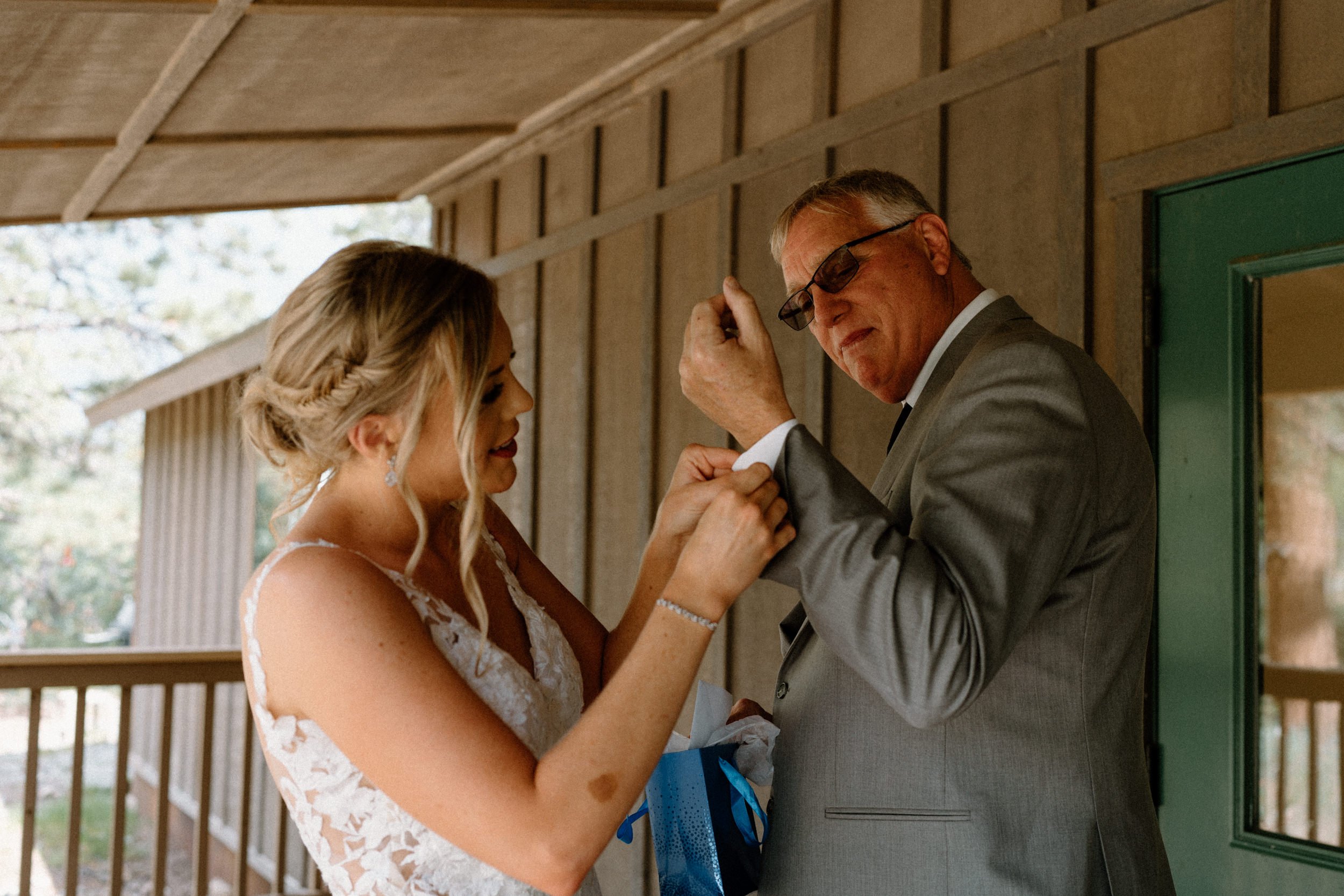 Bride puts the cufflinks on her father's cuffs