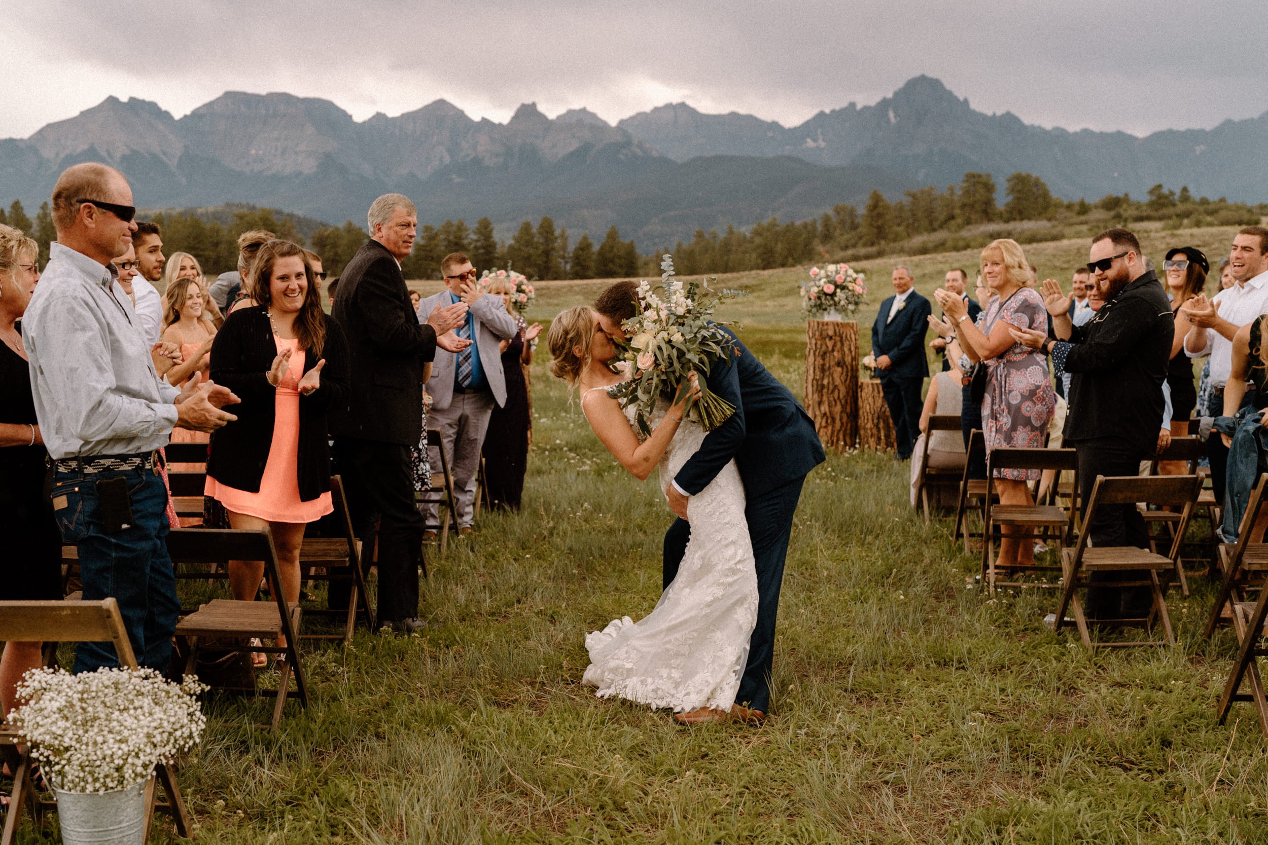 Bride and groom kiss in the middle of the aisle at Top of the Pines in Ridgway, CO