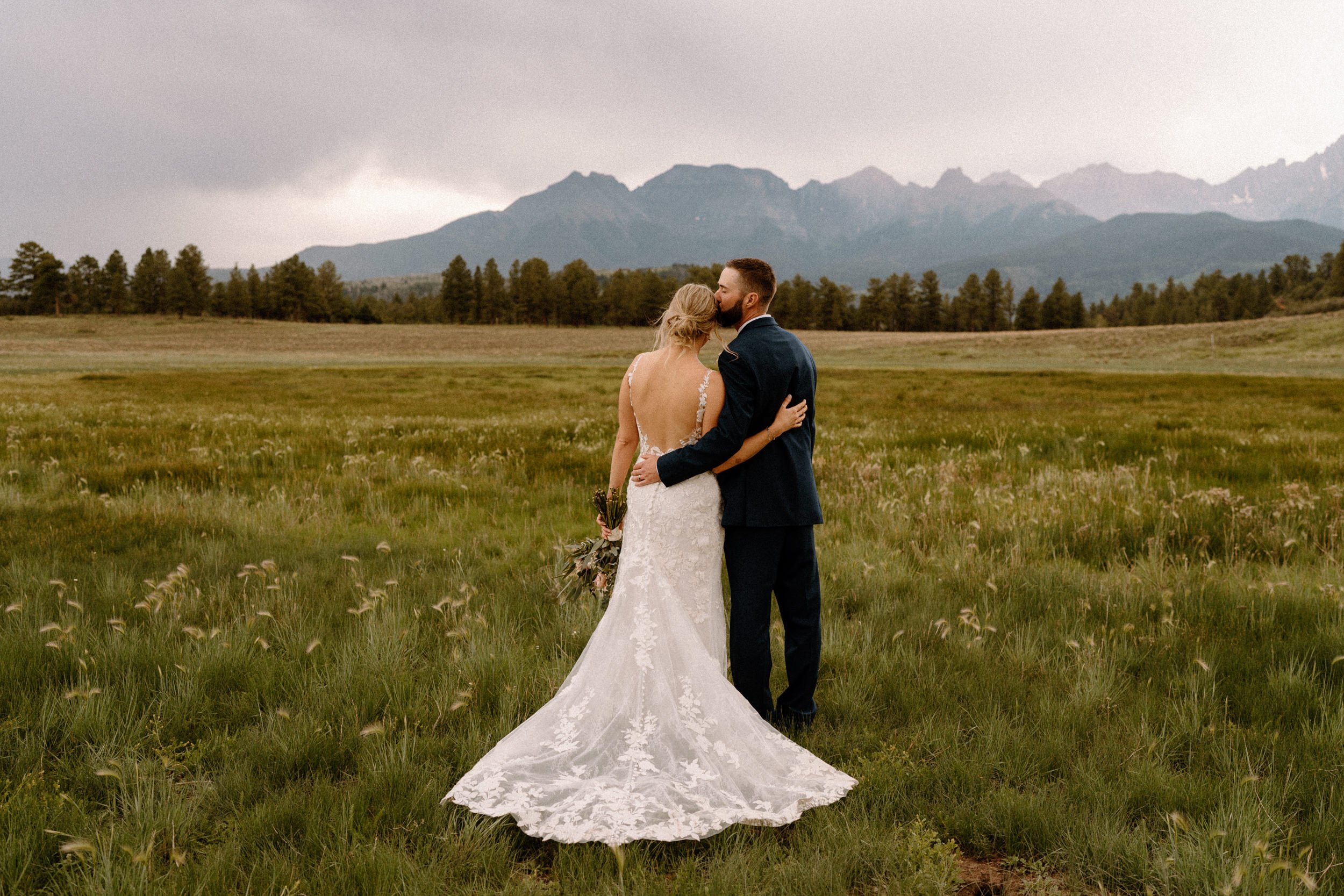 Bride and groom look out to the mountains at Top of the Pines in Ridgway, CO