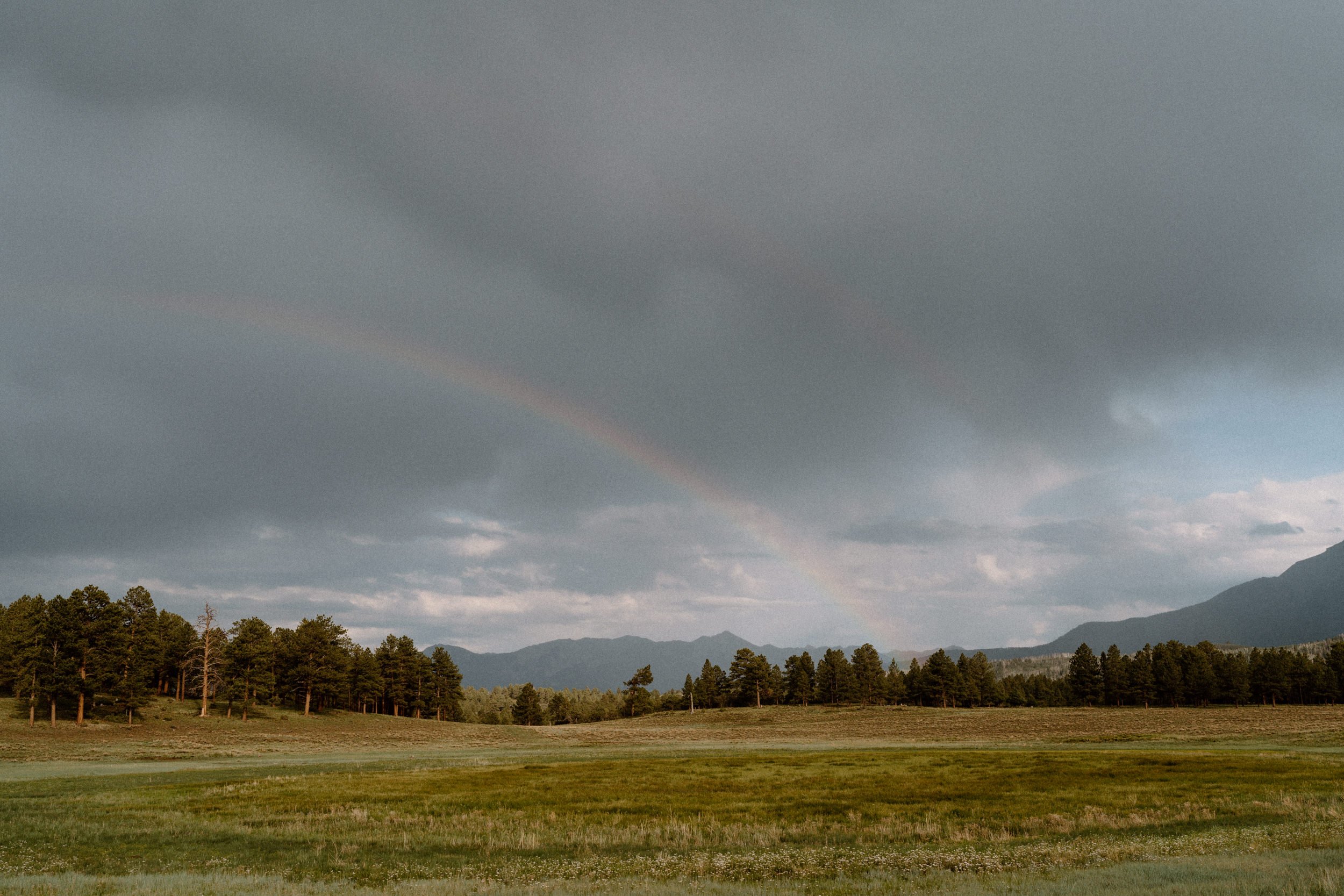 A rainbow appears across the valley at Top of the Pines in Ridgway, CO
