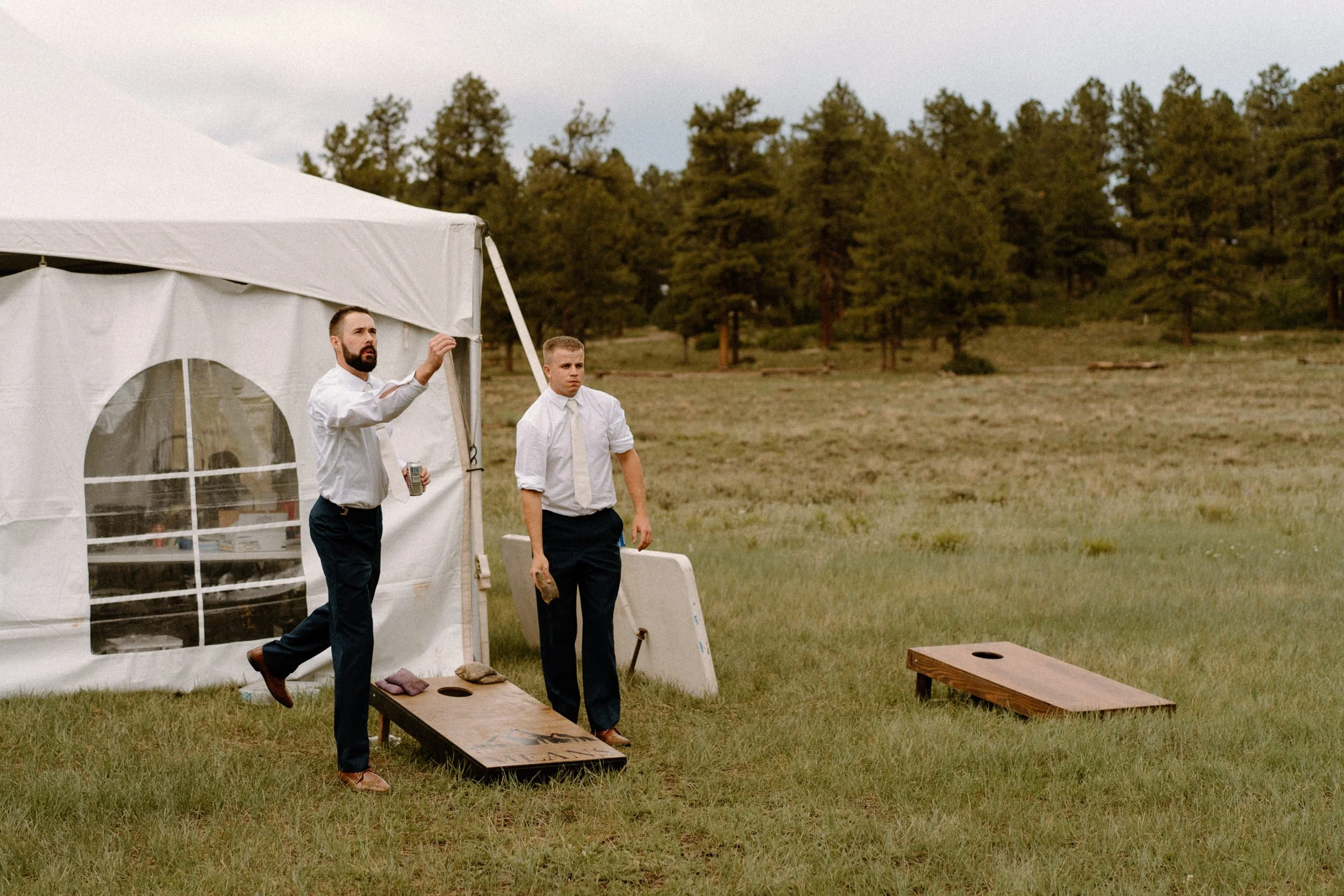 Groom plays corn hole with a groomsman