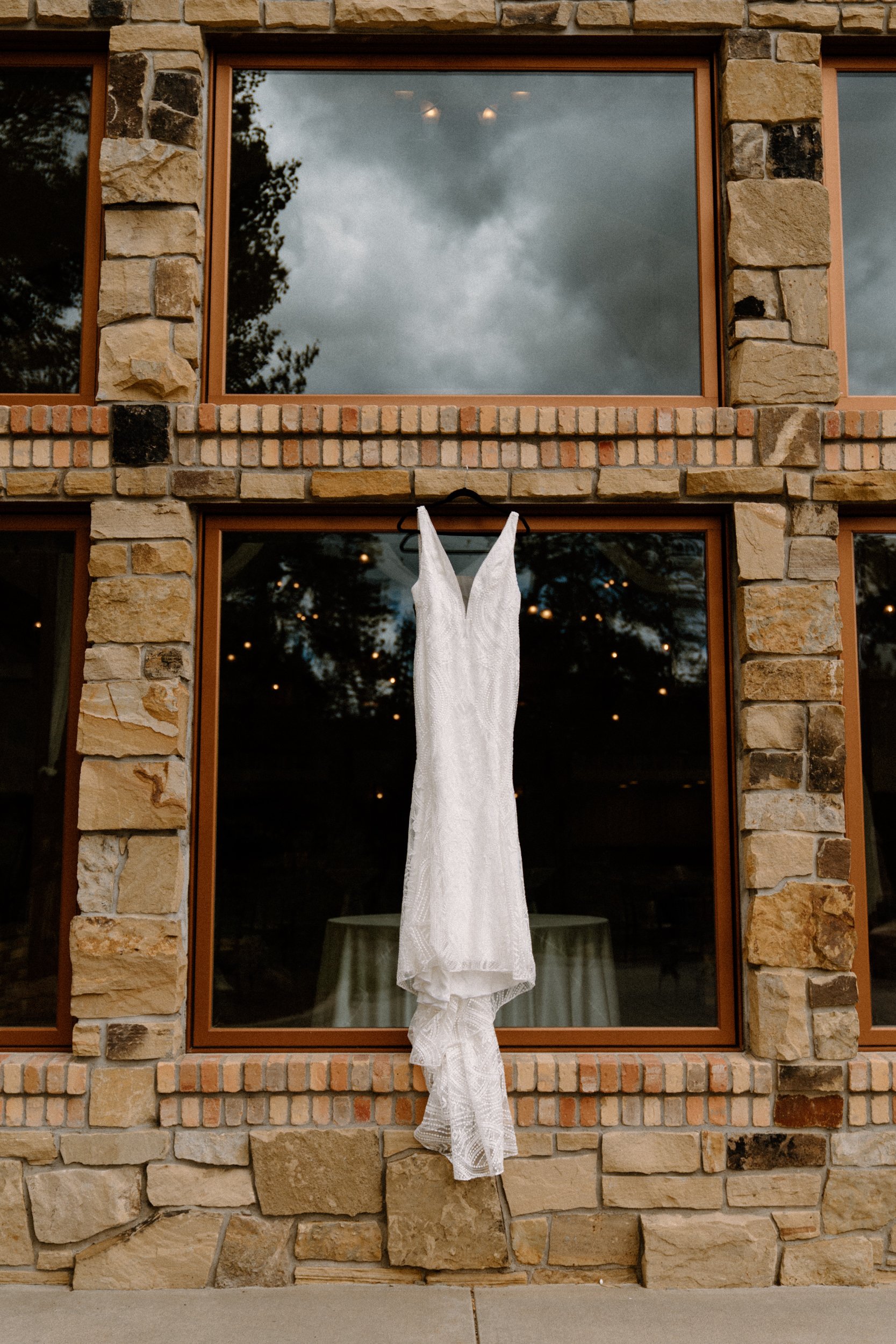 A white wedding dress hangs from the stone wall at Della Terra Mountain Chateau in Estes Park, CO