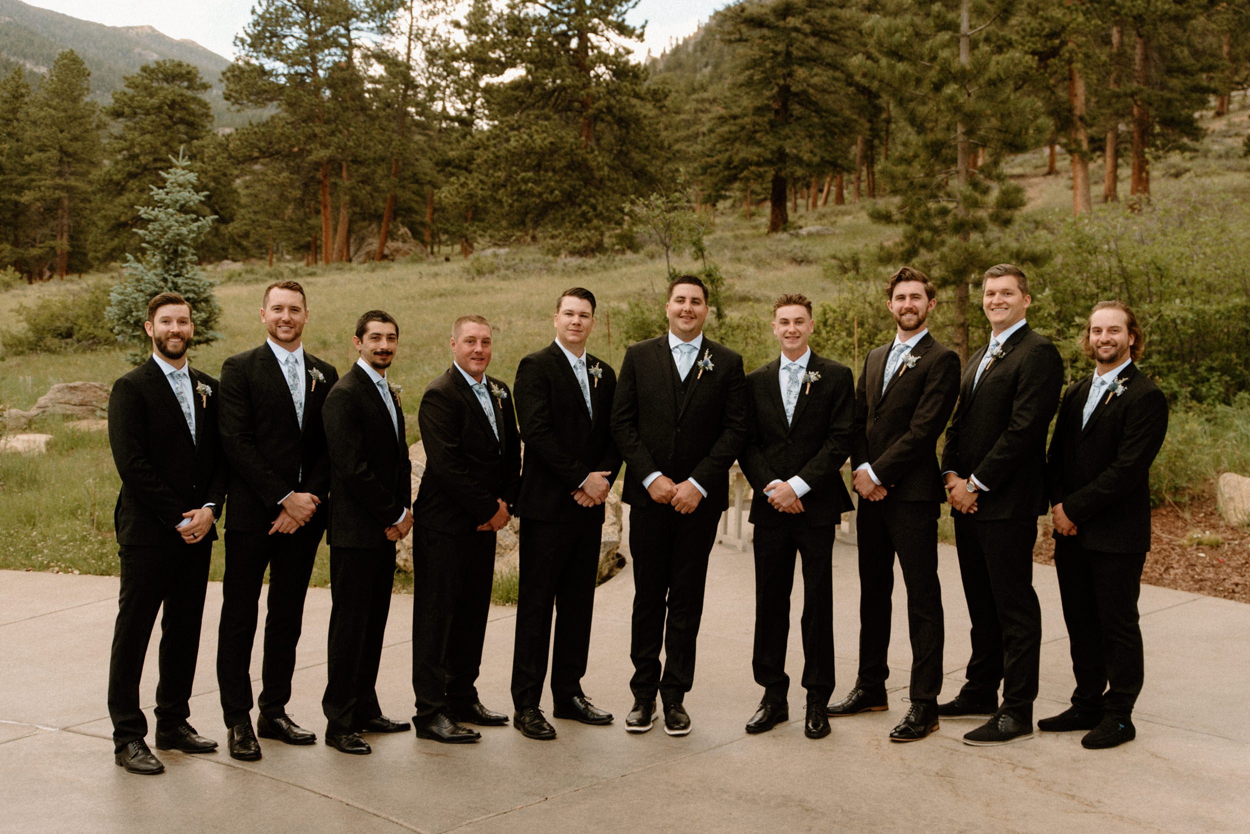 The groom poses with his groomsmen outside of the Della Terra Mountain Chateau in Estes Park, CO