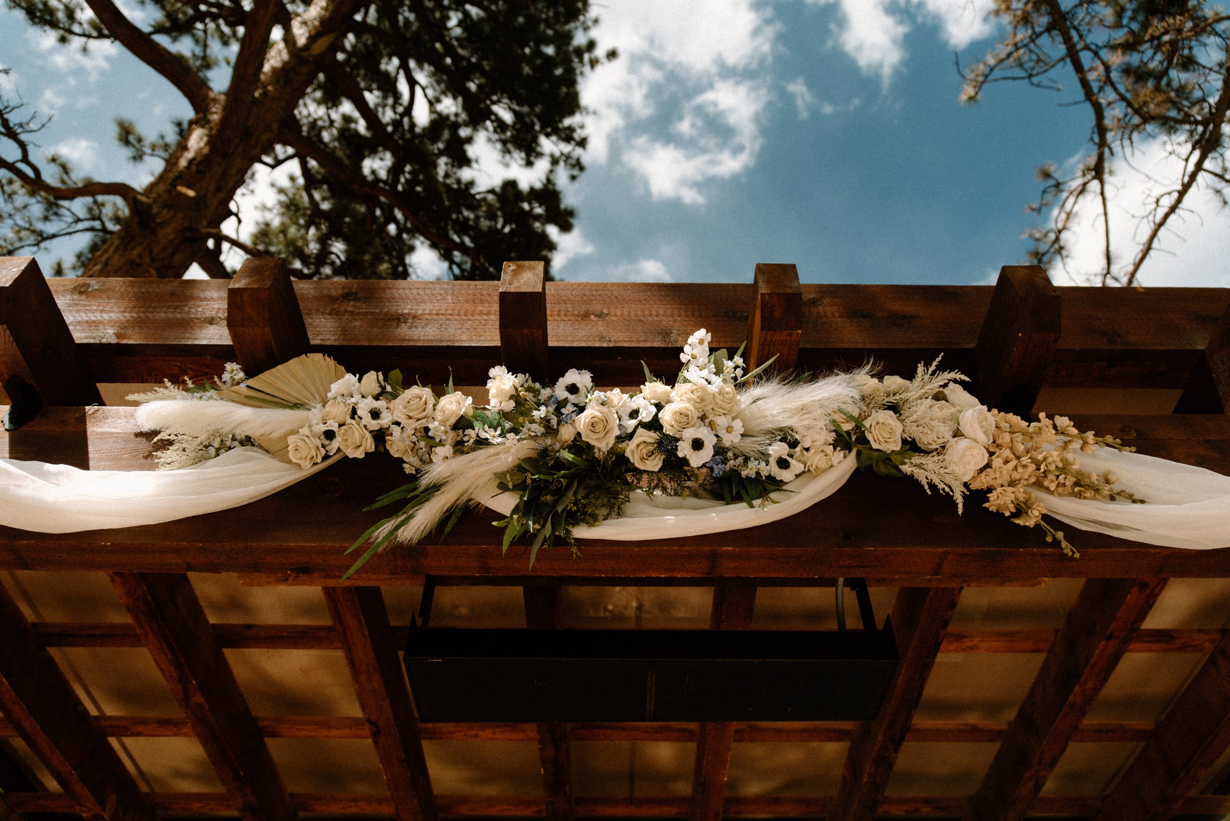 White and green florals decorate the wooden altar at Della Terra Mountain Chateau in Estes Park, CO