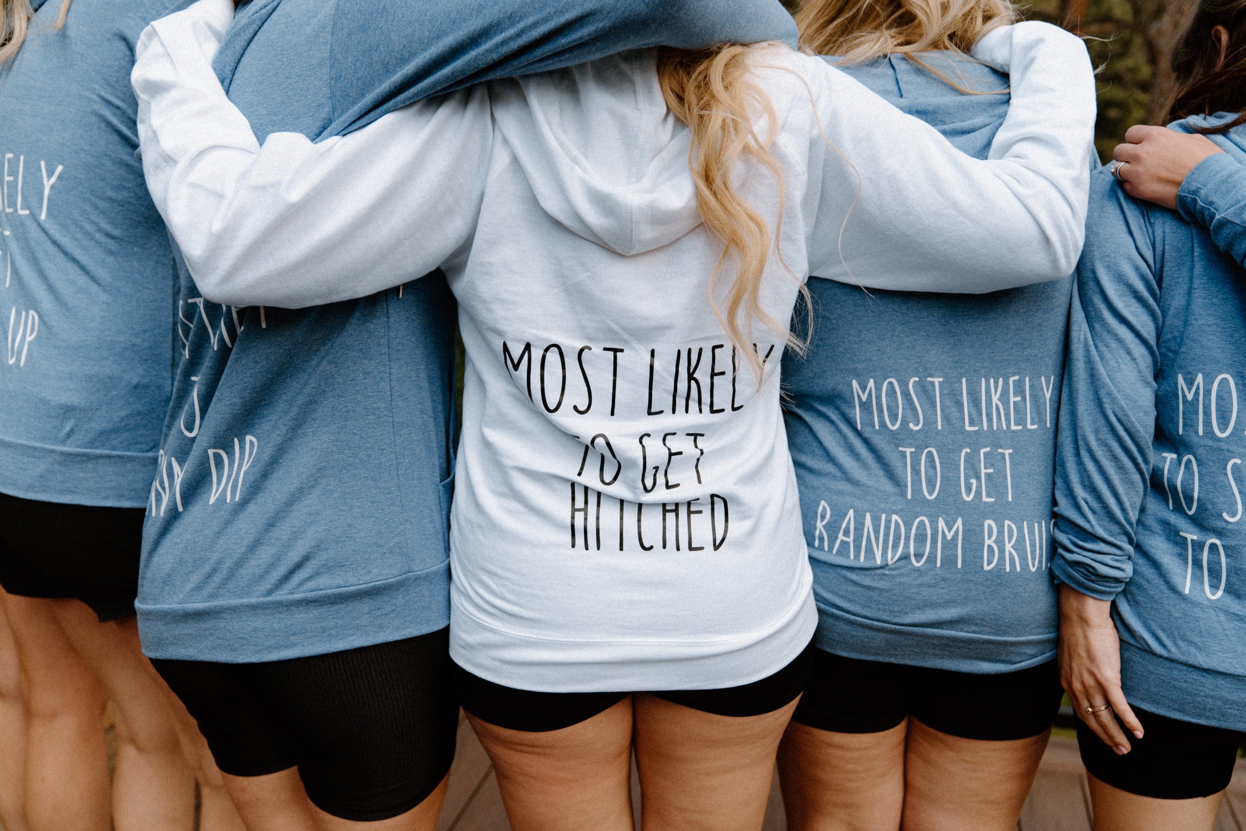 The bridal party turns the other way to show off their customized "Most Likely" jackets