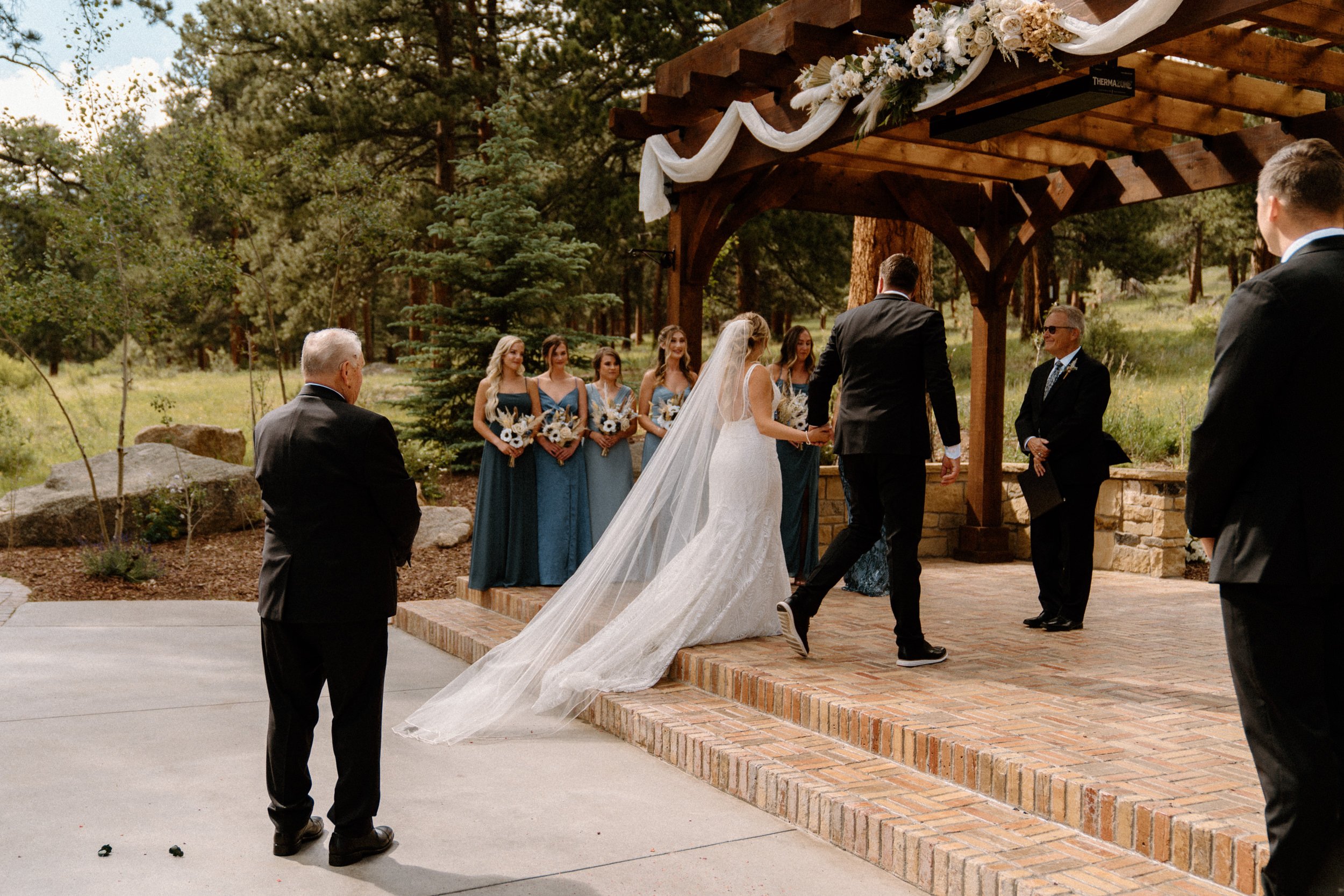 The bride and groom walk up to the altar together at Della Terra Mountain Chateau in Estes Park, CO