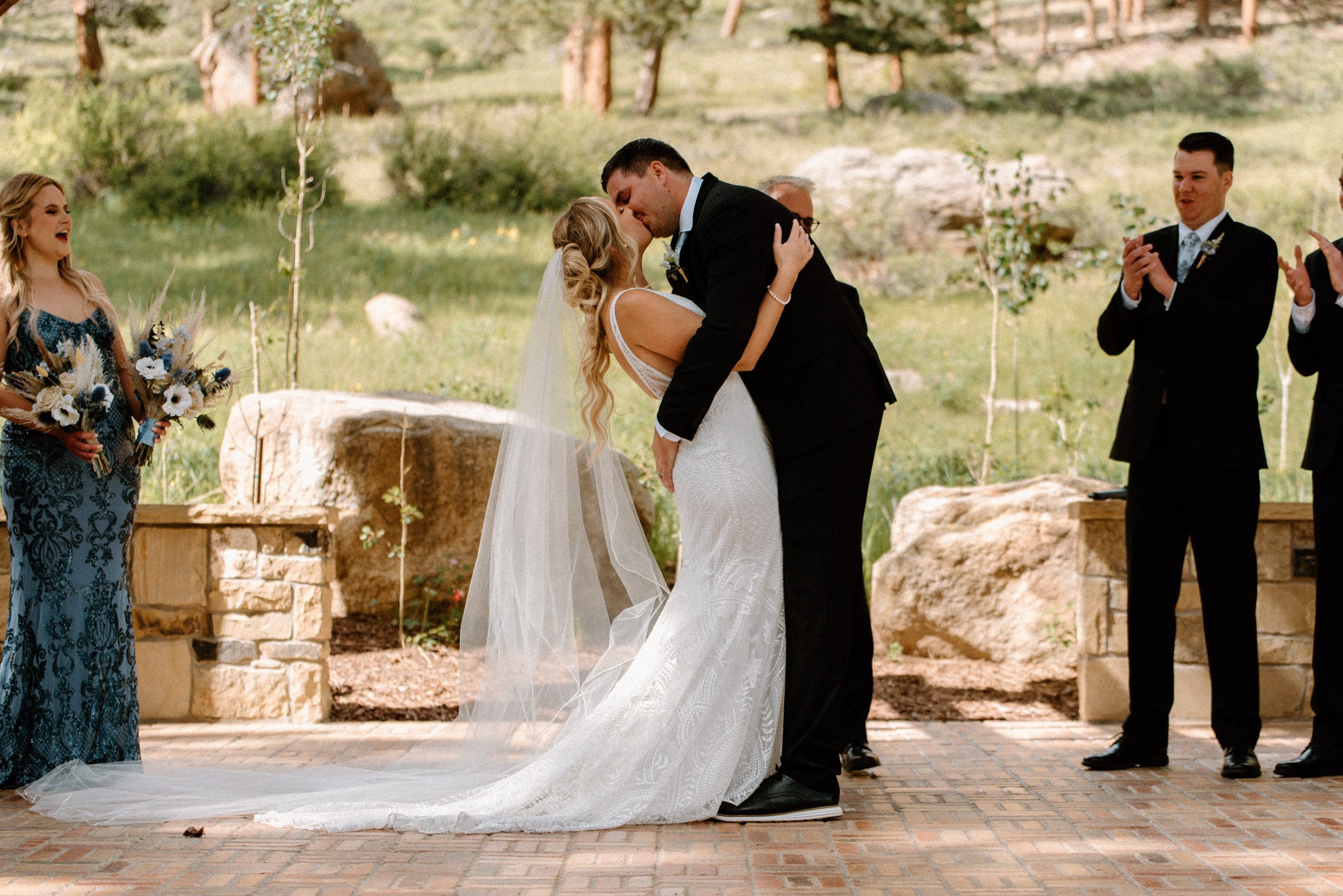 The bride and groom share their first kiss at the altar at the Della Terra Mountain Chateau in Estes Park, CO