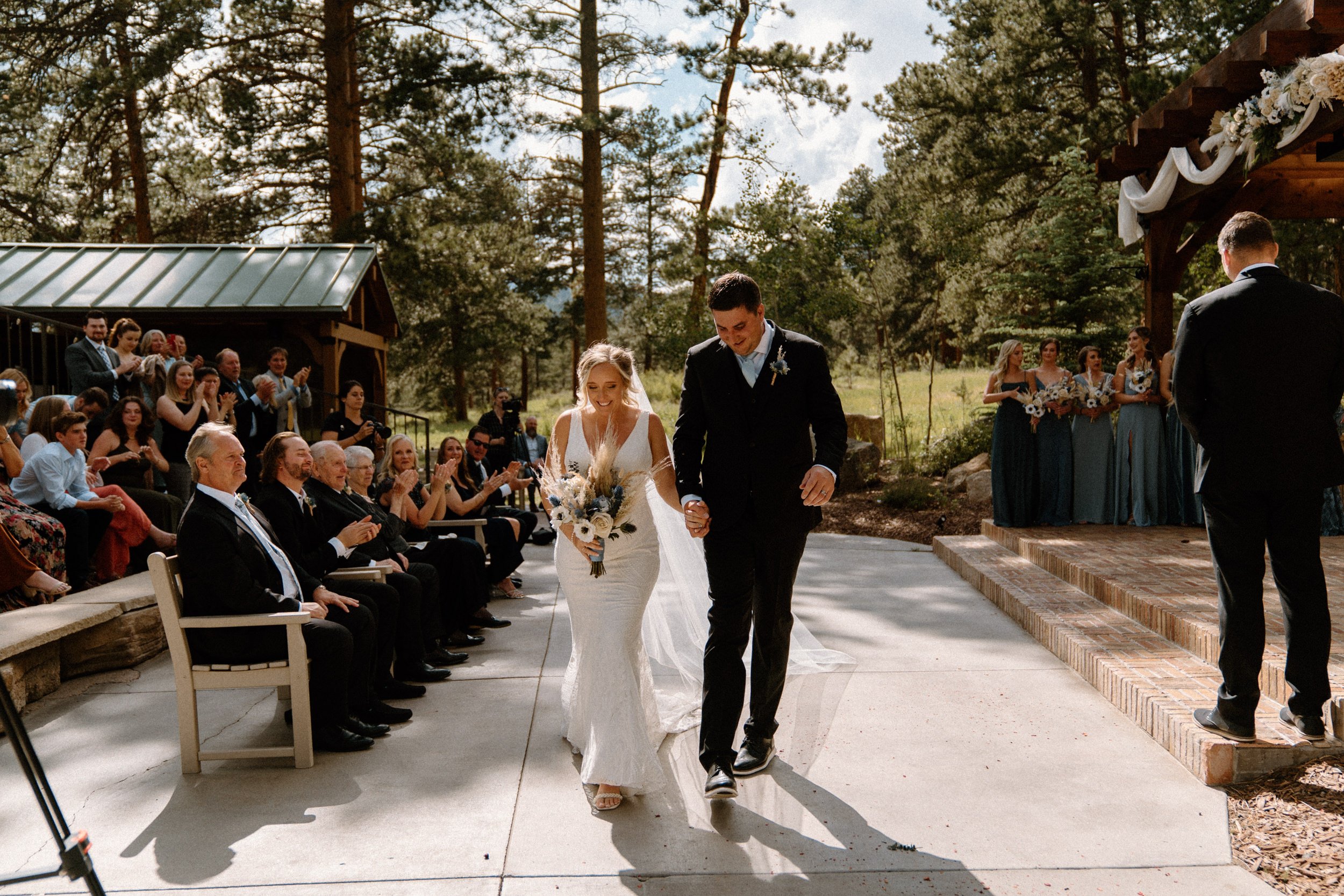 The bride and groom walk down the aisle together at the Della Terra Mountain Chateau in Estes Park, CO