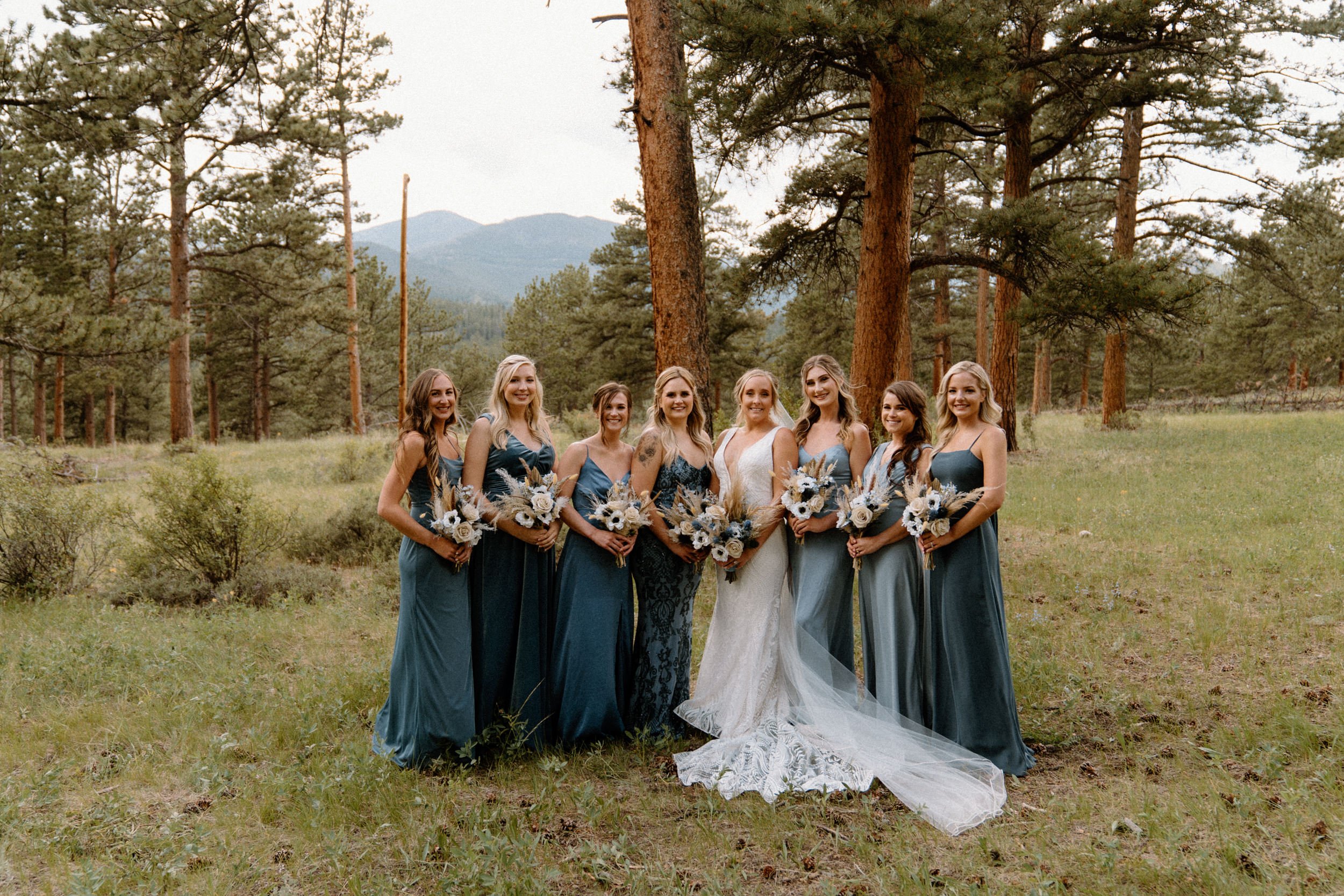 The bride poses with her bridesmaids outside of the Della Terra Mountain Chateau in Estes Park, CO