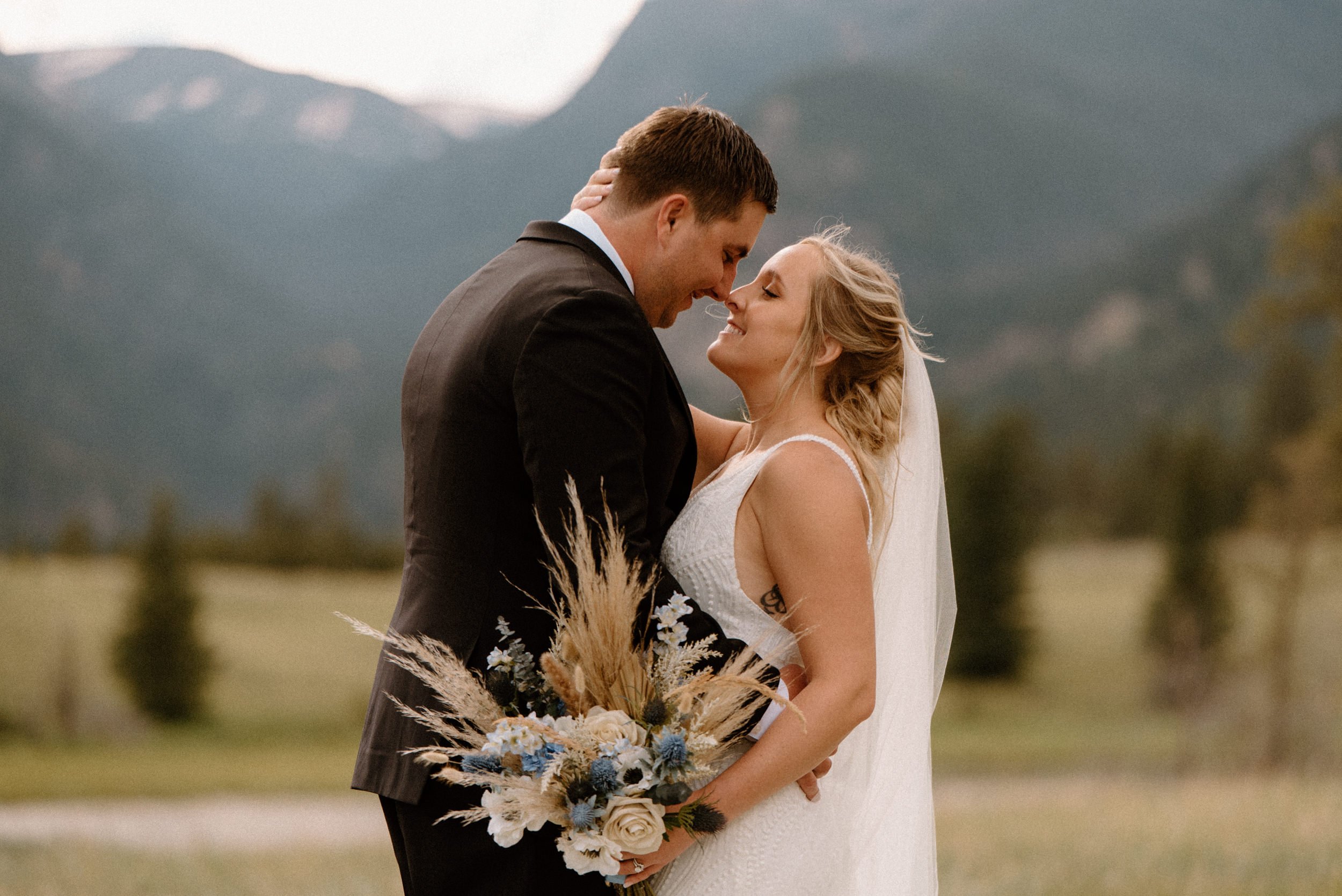 The bride and groom kiss in a mountain valley in Estes Park, CO