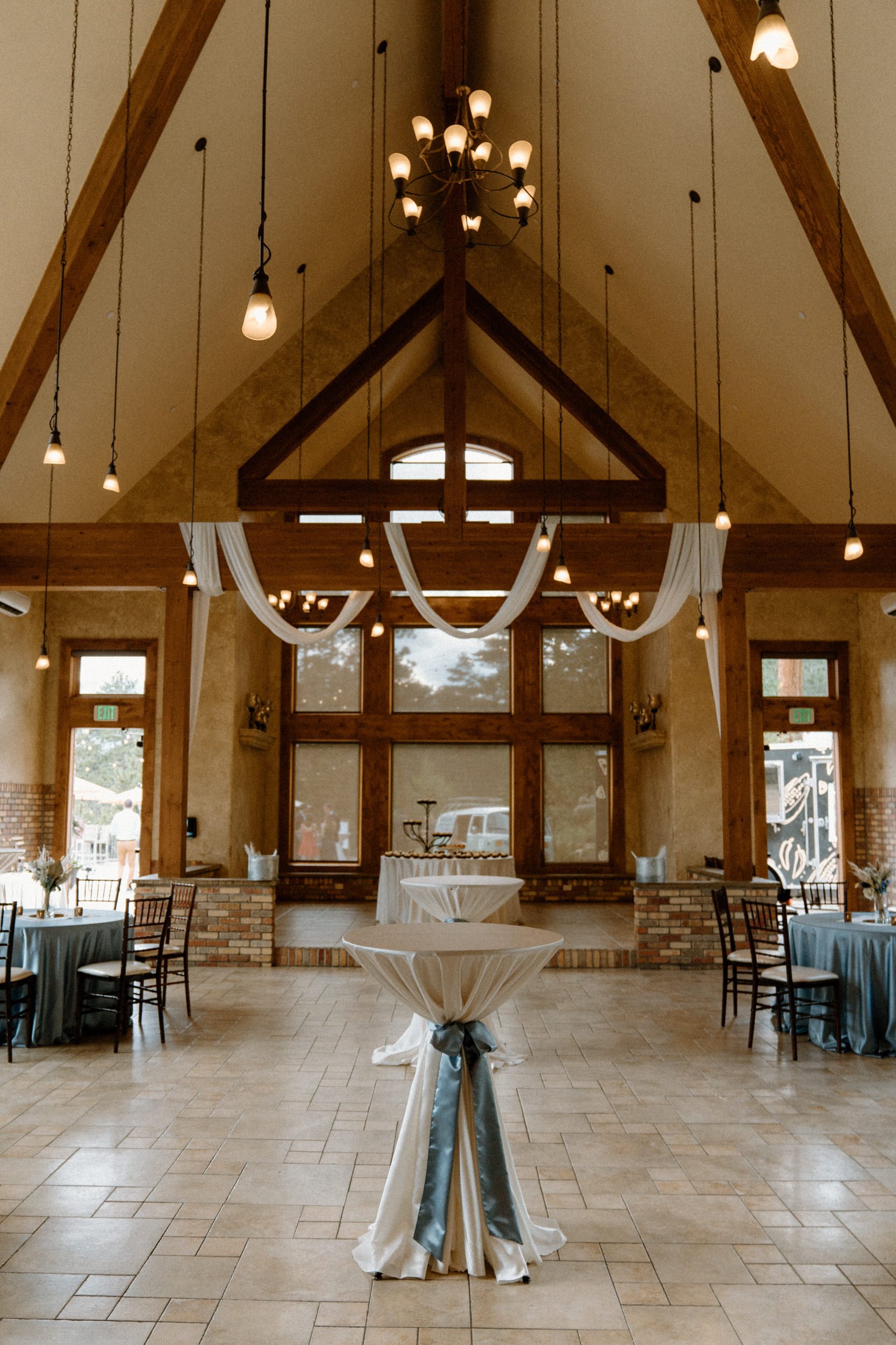 The reception area decorated with white drapes and blue table covers at the Della Terra Mountain Chateau in Estes Park, CO