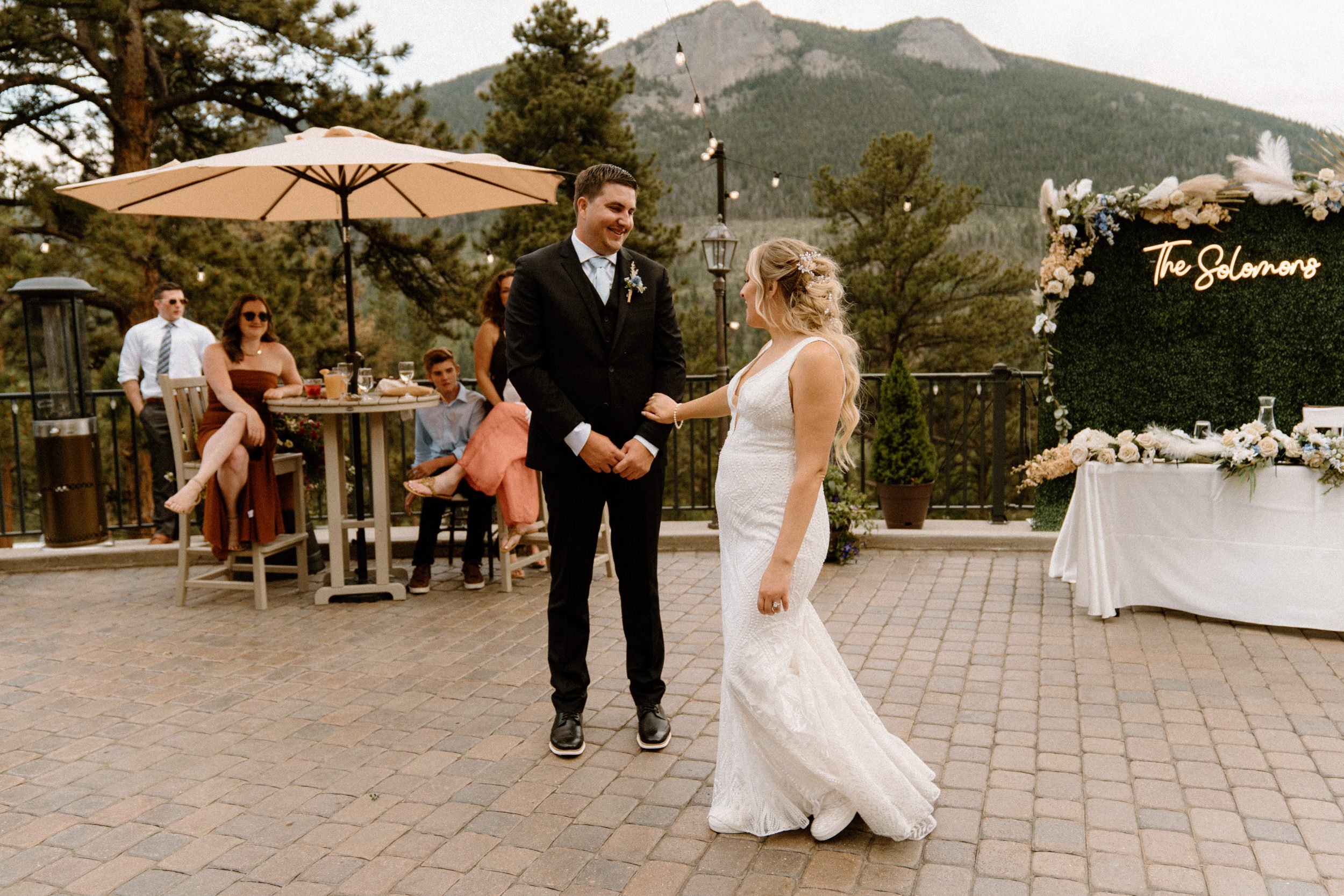 The bride and groom share their first dance on the outdoor patio at the Della Terra Mountain Chateau in Estes Park, CO