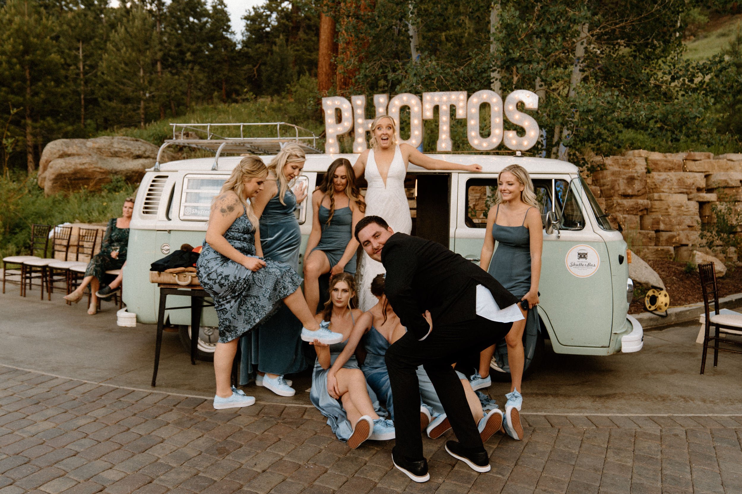 The bridal party and the groom pose in front of the photo booth bus