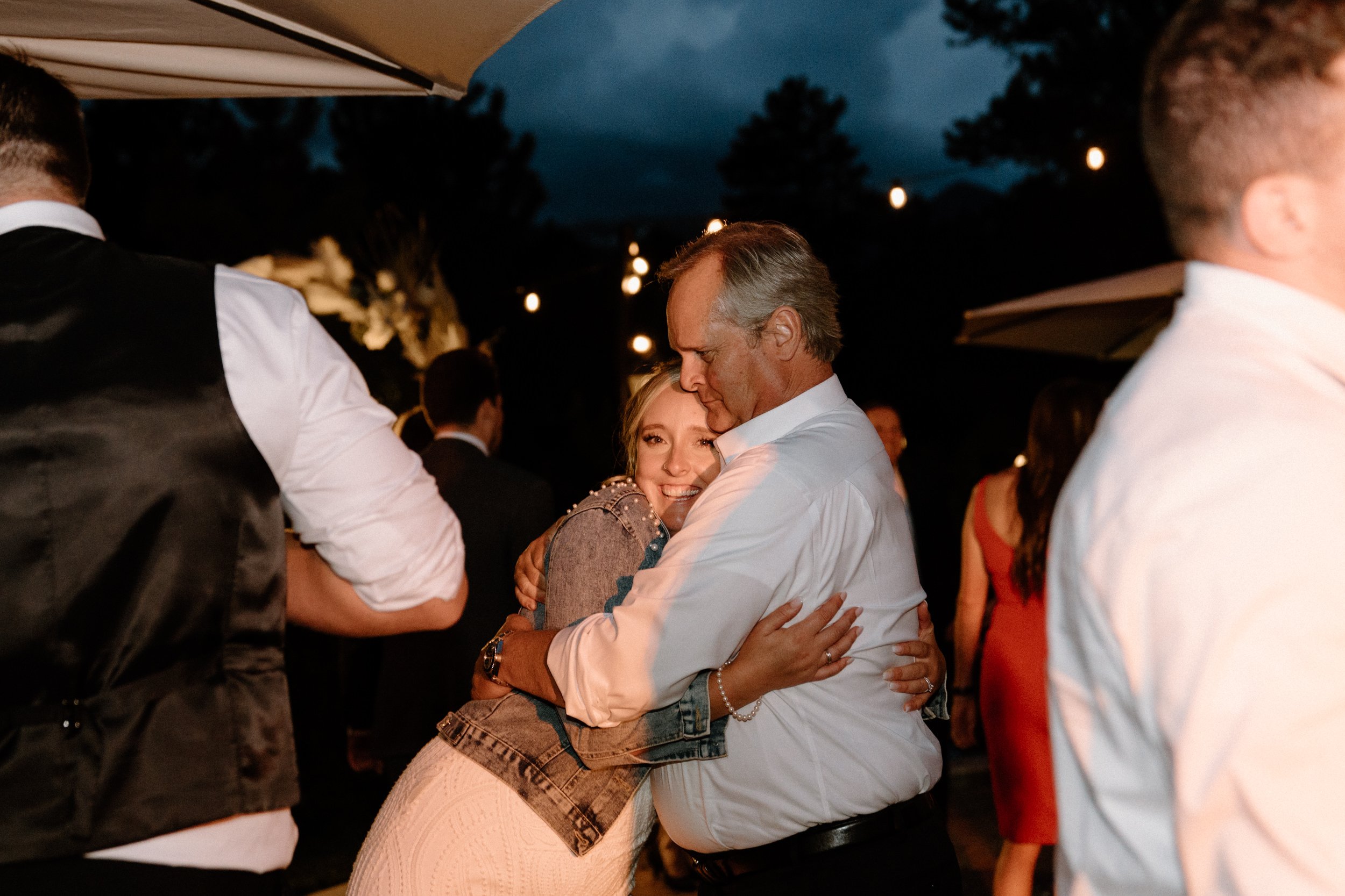 The bride hugs her father on the dance floor