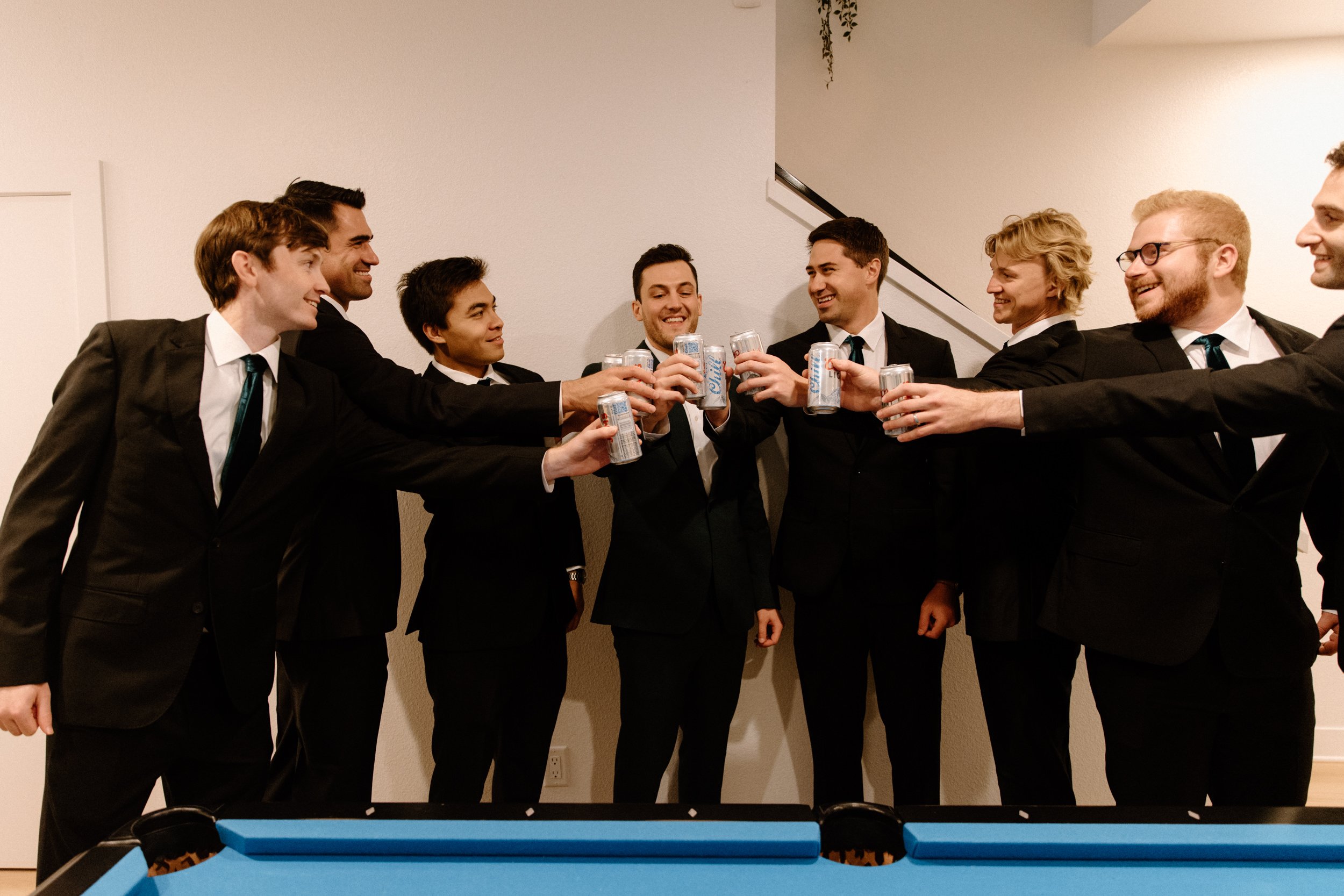 The groomsmen toast with beer cans