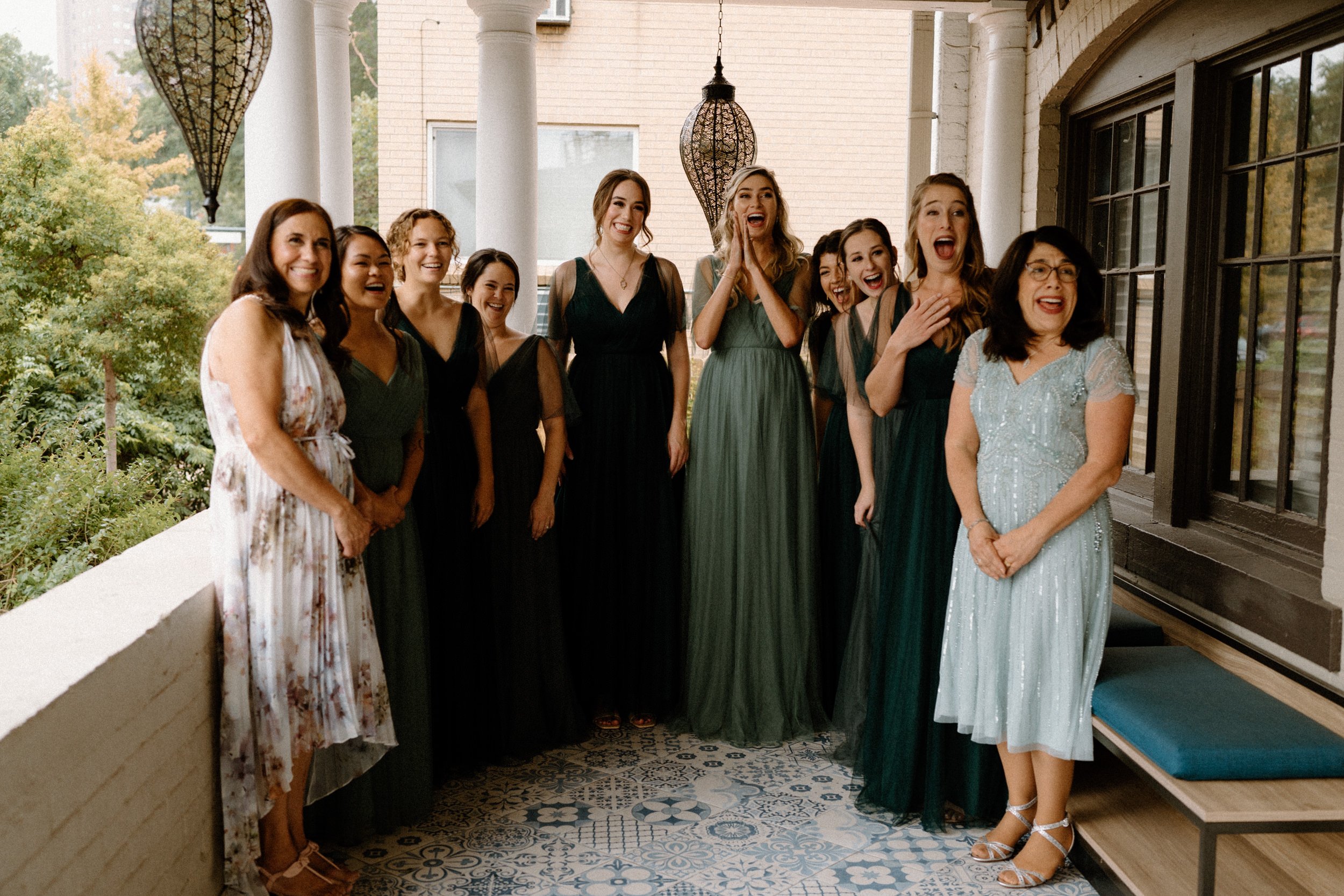 The bridesmaids smile in shock as they see the bride for the first time