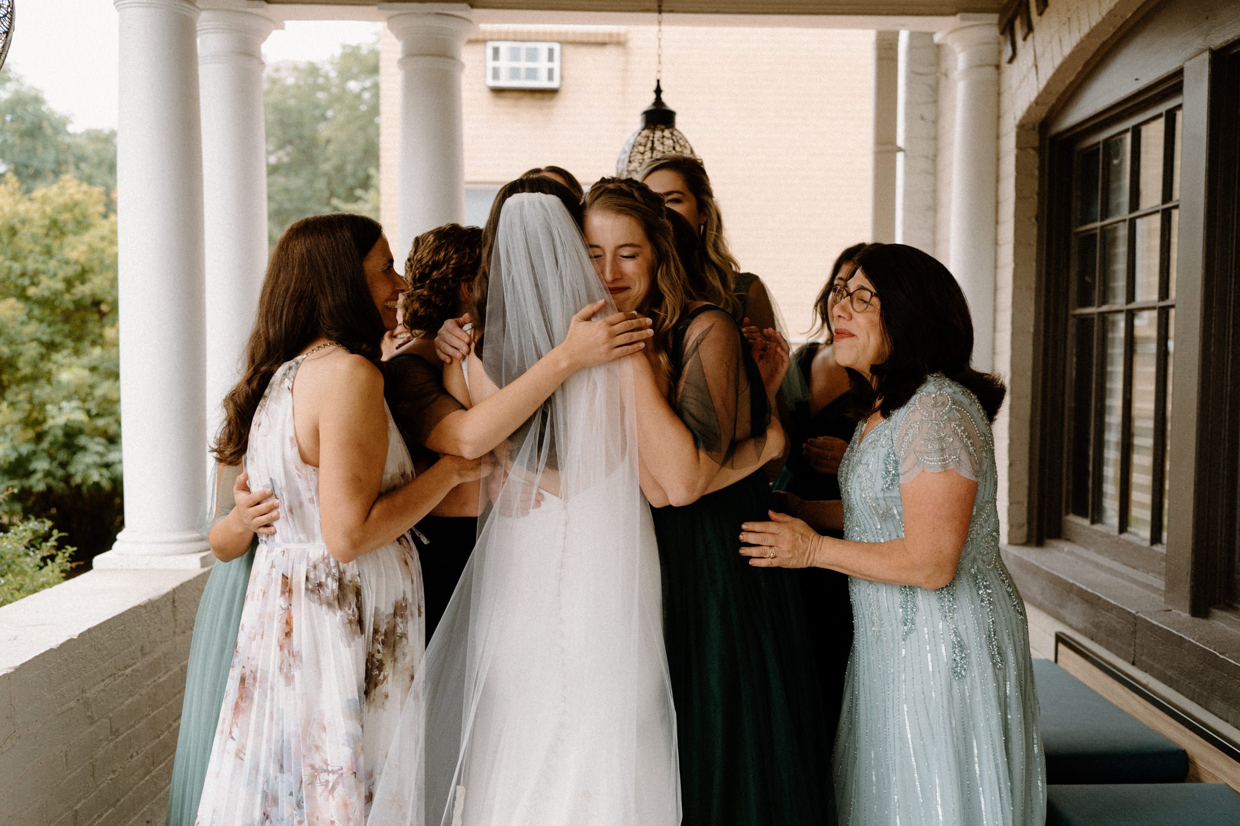 The bridesmaids embrace the bride