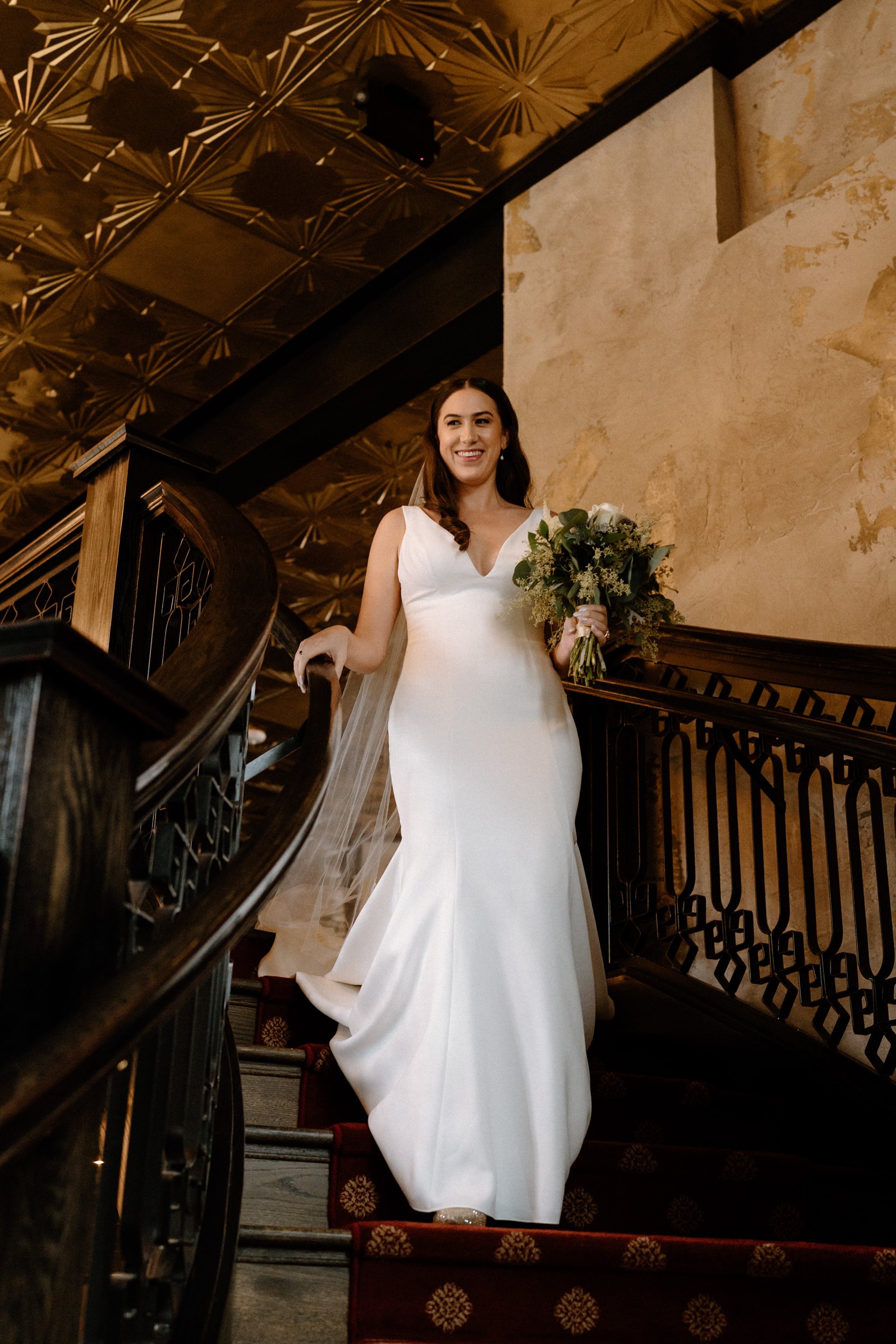 The bride walks down the staircase at Ironworks in Denver, CO