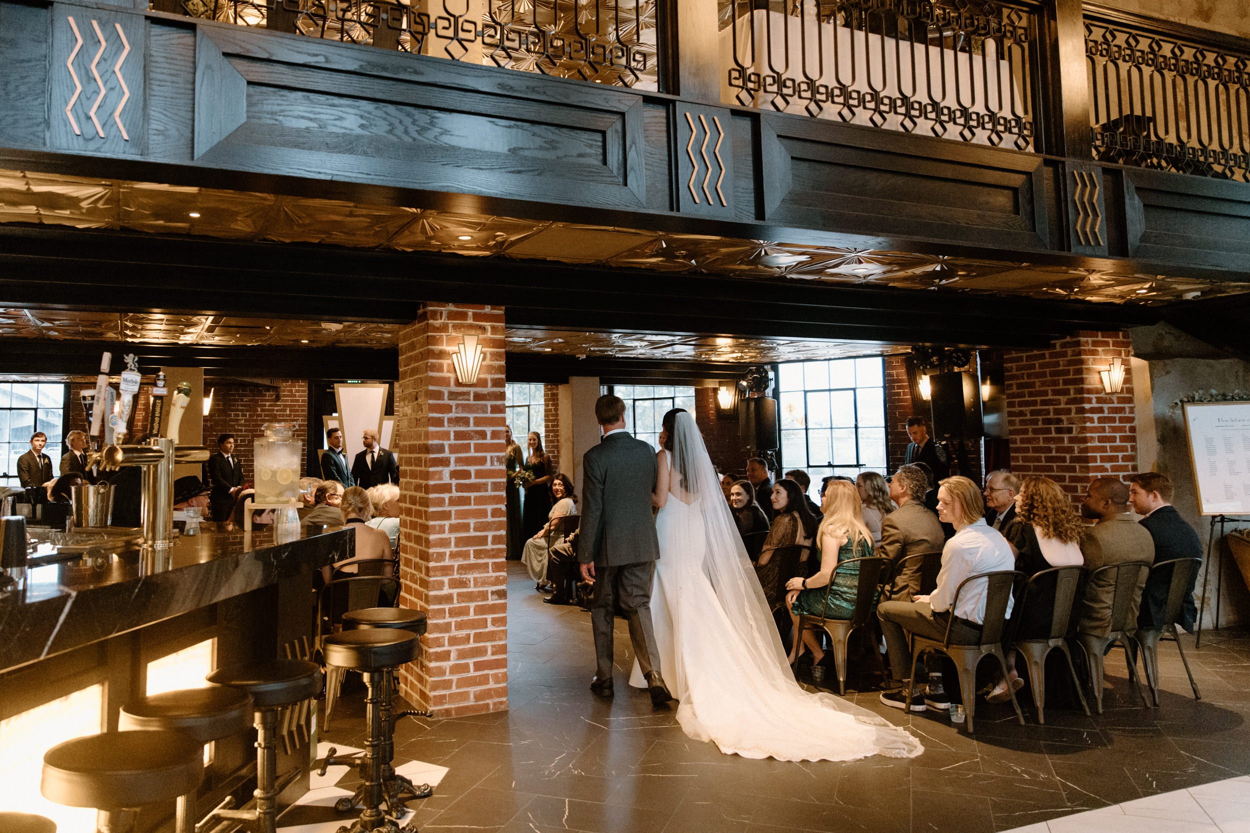 The bride and her father walk down the aisle at Ironworks in Denver, CO