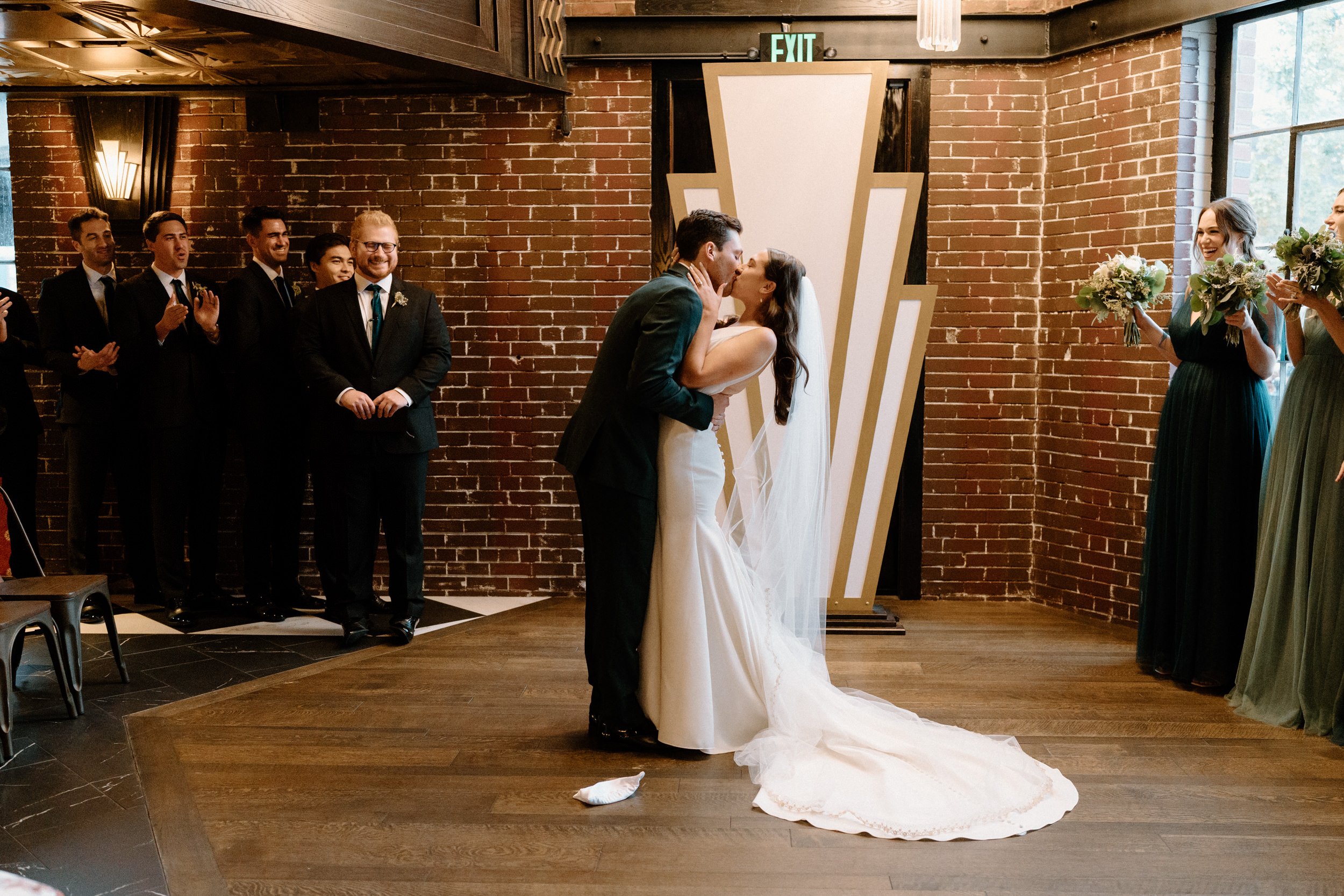 The bride and groom share their first kiss at Ironworks in Denver, CO
