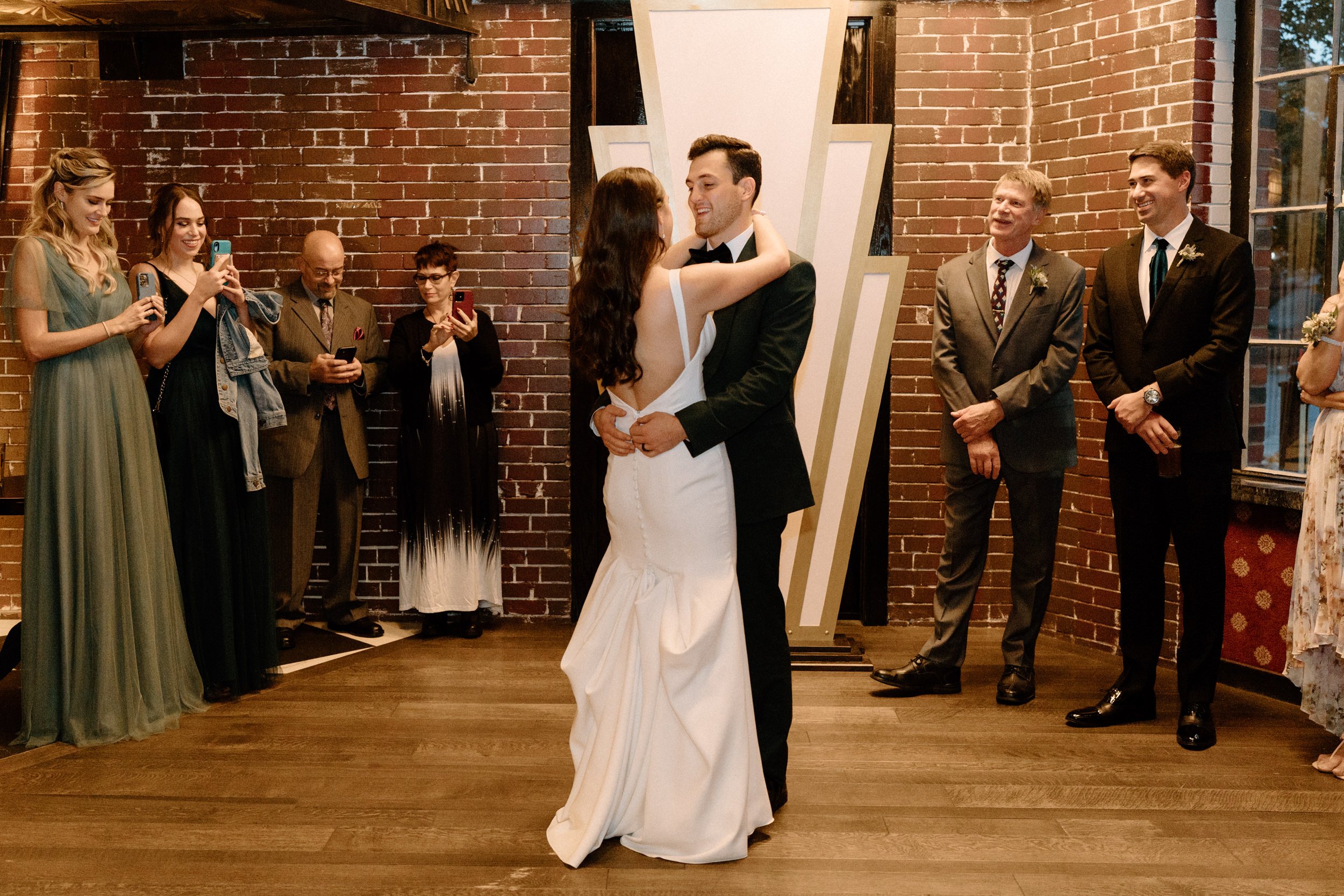The bride and groom smile at each other as they share their first dance