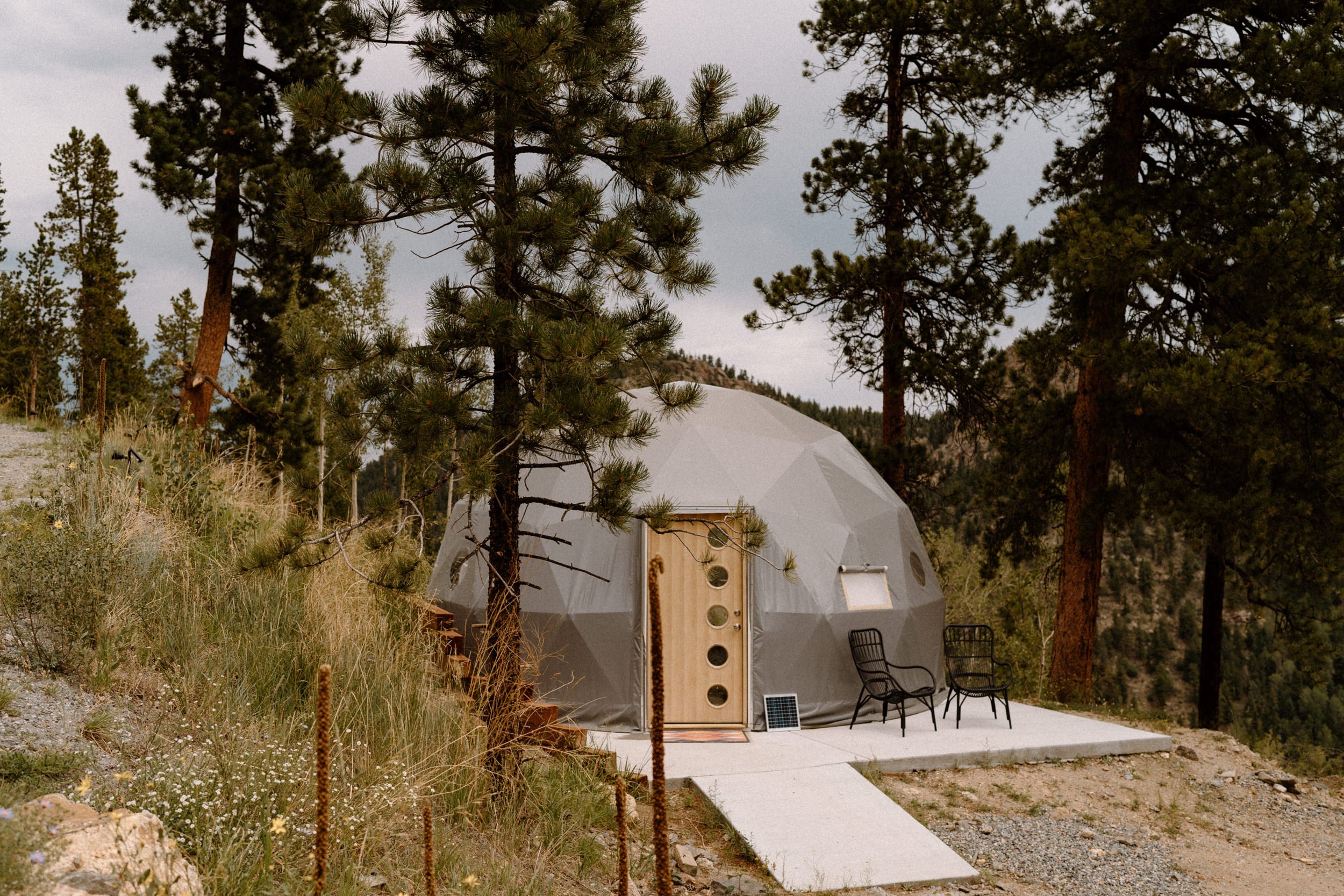 A modern gray glamping dome located at North Star Gatherings in Idaho Springs, CO