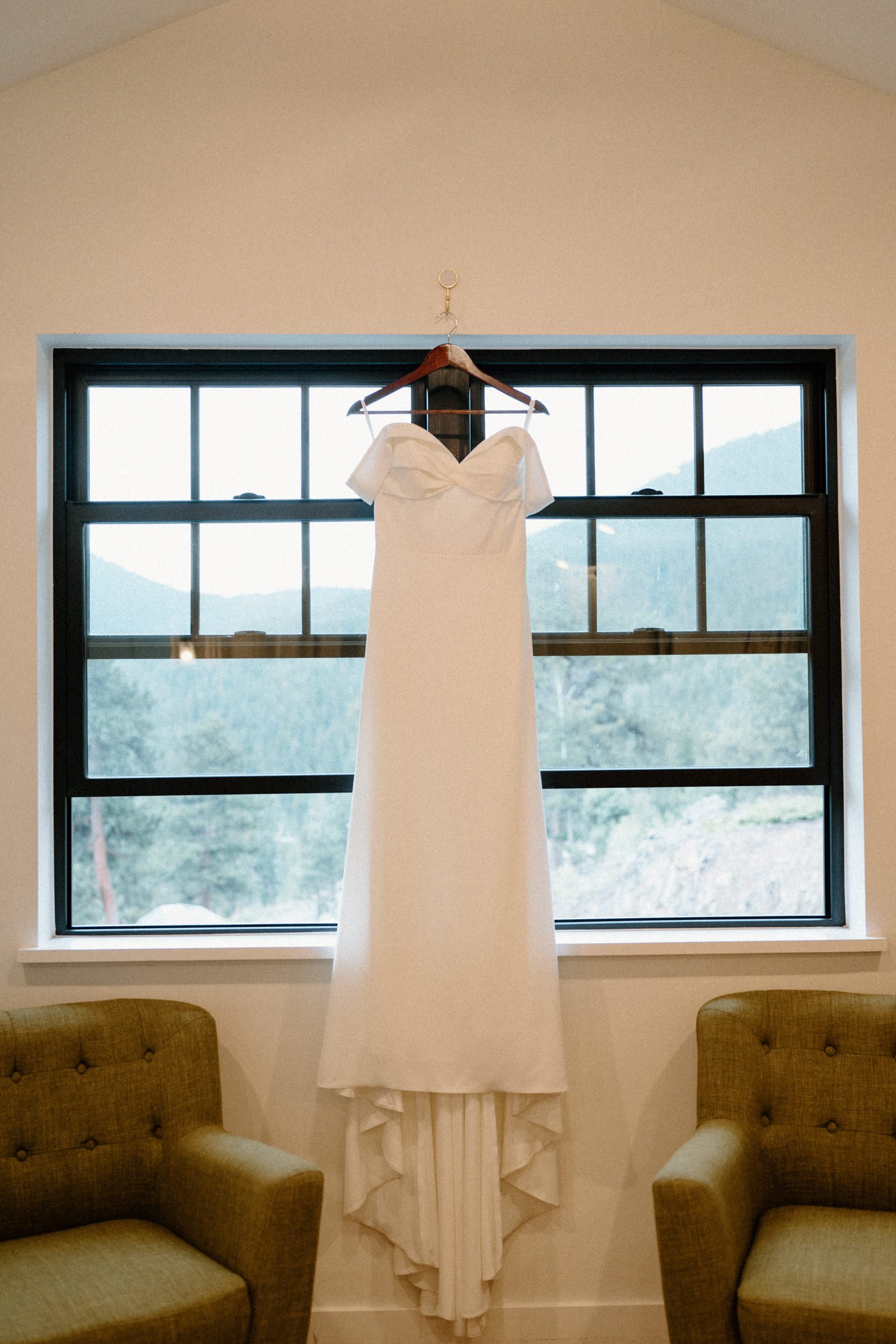 A white wedding dress hangs from the window 