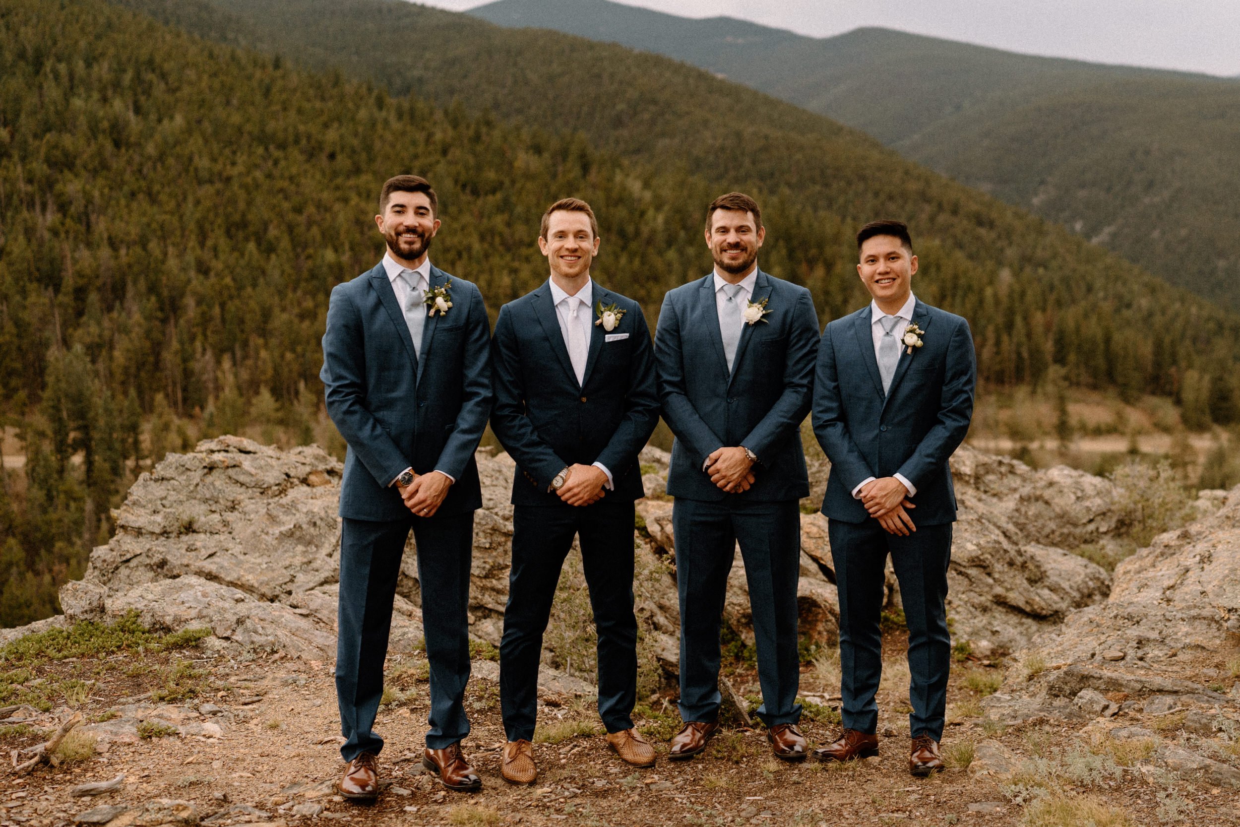 The groomsmen pose on a mountain overlook at North Star Gatherings in Idaho Springs, CO