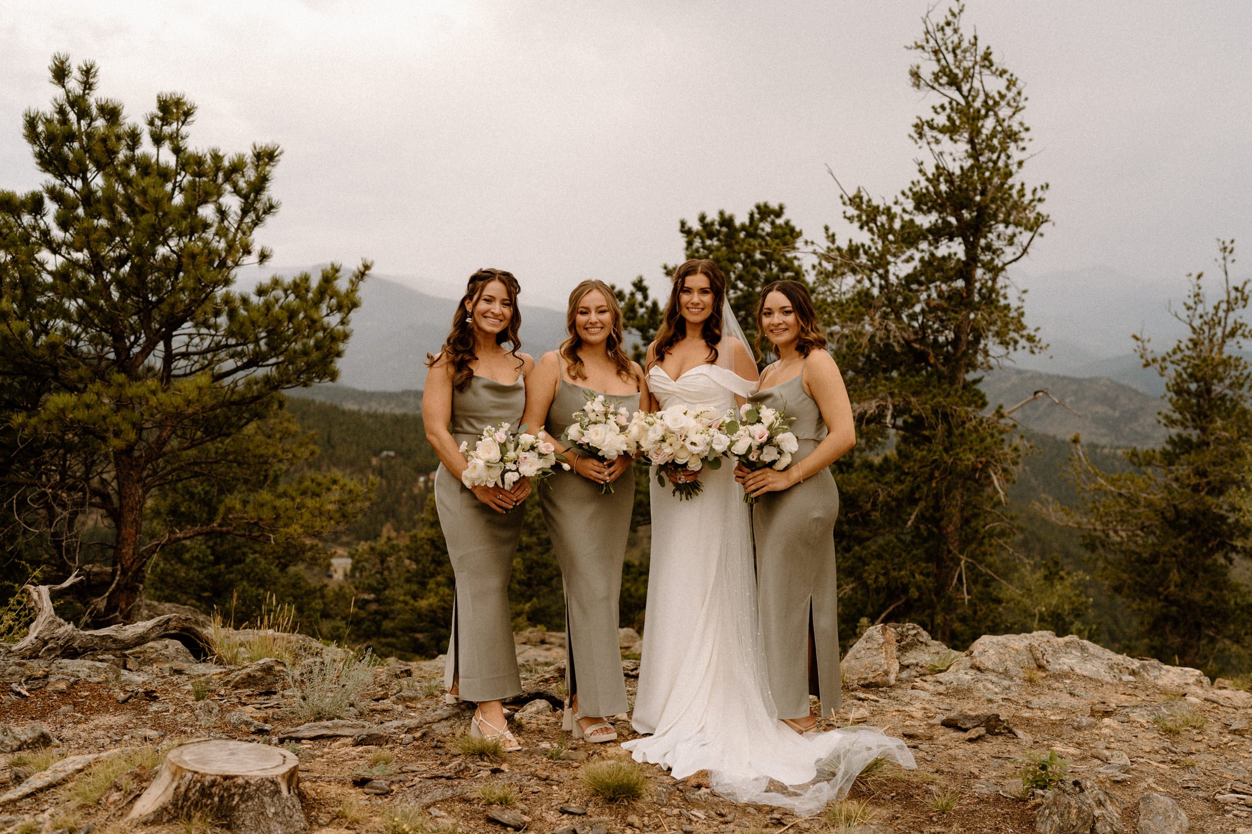 The bride poses with her bridesmaids outside of North Star Gatherings in Idaho Springs, CO