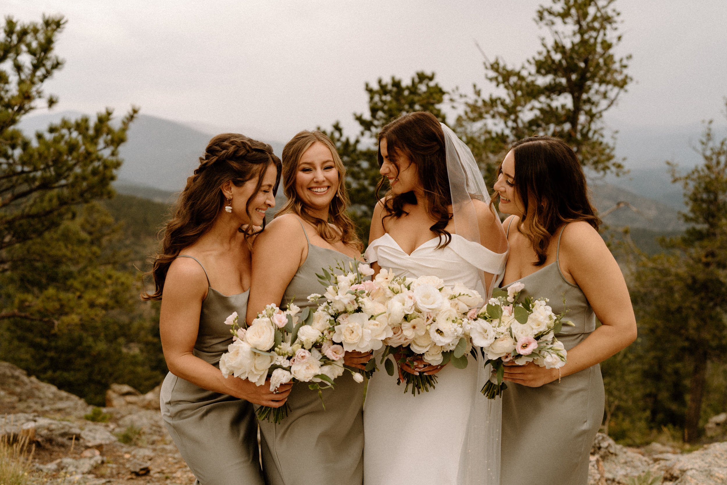 The bride laughs with her bridesmaids