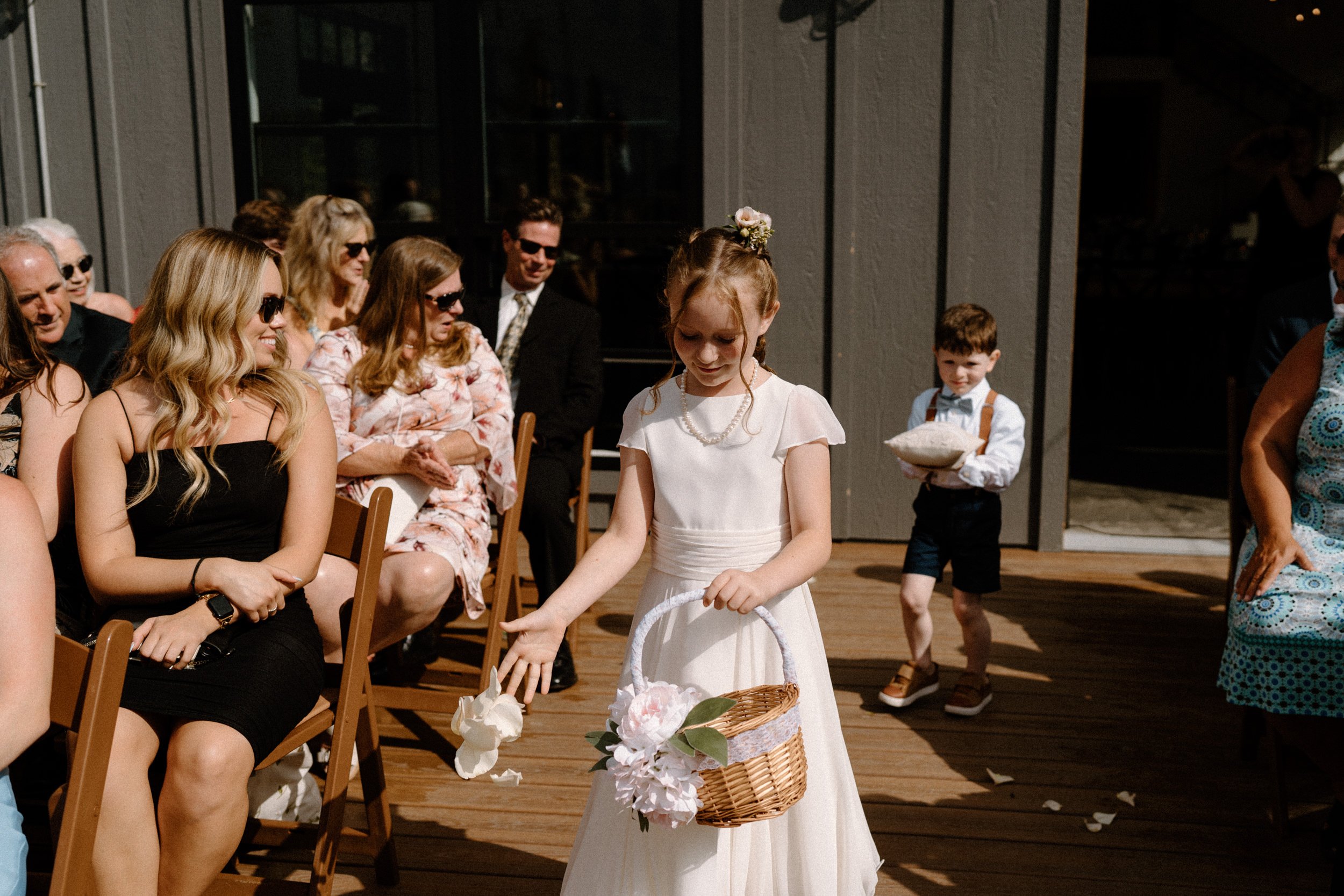 A flower girl tosses petals as she walks down the aisle
