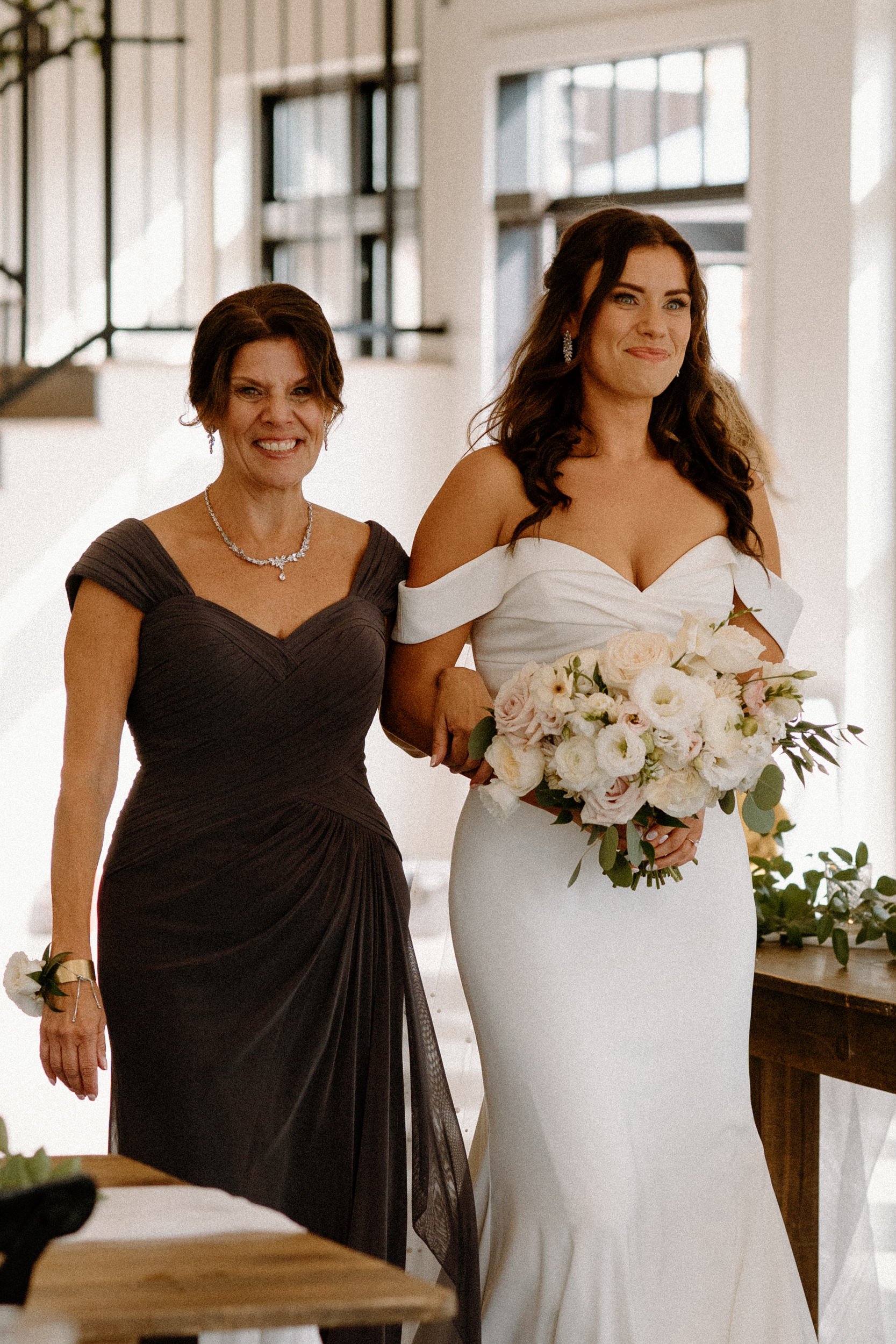The bride and her mother walk down the aisle together