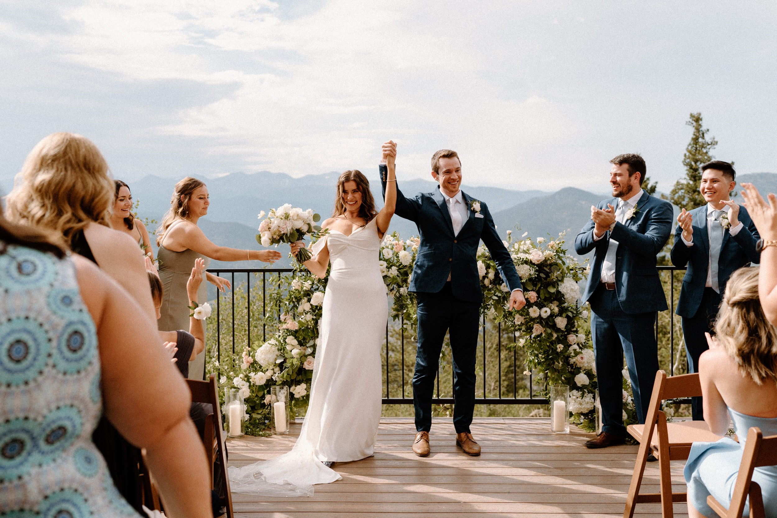 The bride and groom raise their hands in celebration at the altar at North Star Gatherings in Idaho Springs, CO